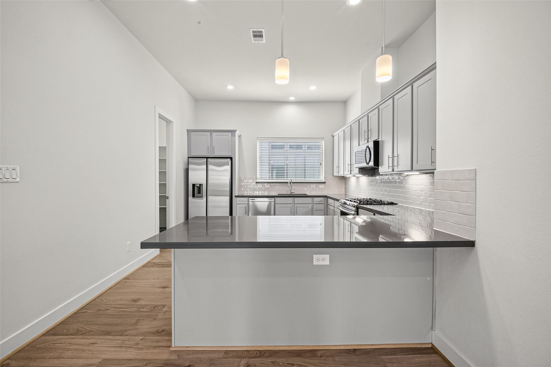 Modern kitchen with sleek gray cabinetry, stainless steel appliances, and a spacious island perfect for entertaining.