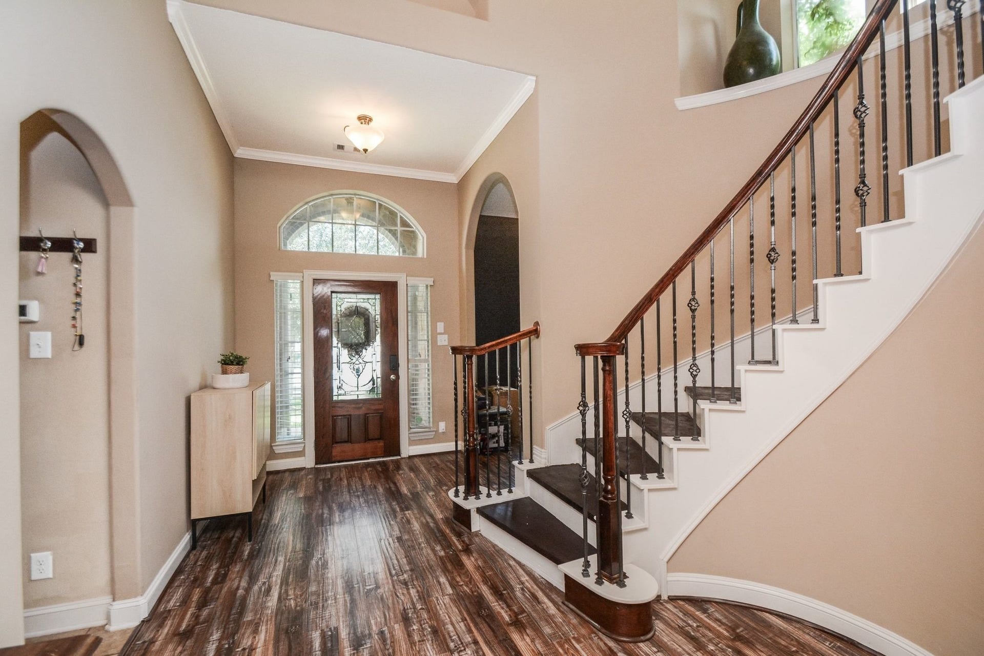 Large entry with curved staircase with wrough itron spindles.