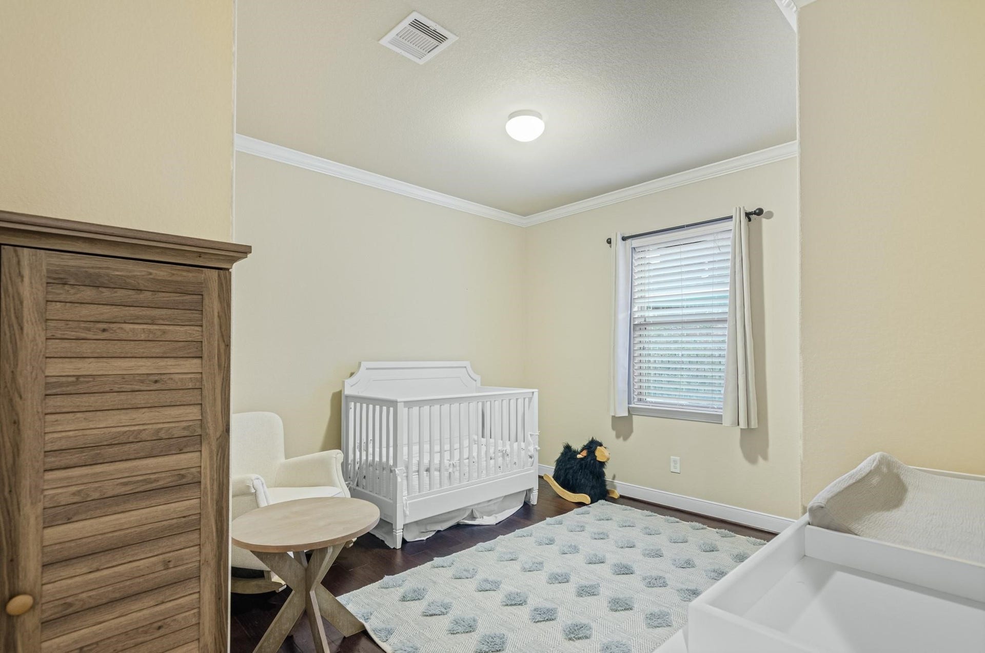 103 W Wading Pond Circle, Tomball, TX 77375 Bright and flexible, this secondary bedroom features warm neutral walls, crown molding, and wood flooring, ready to serve as a restful nursery, childs bedroom, or dedicated hobby space.