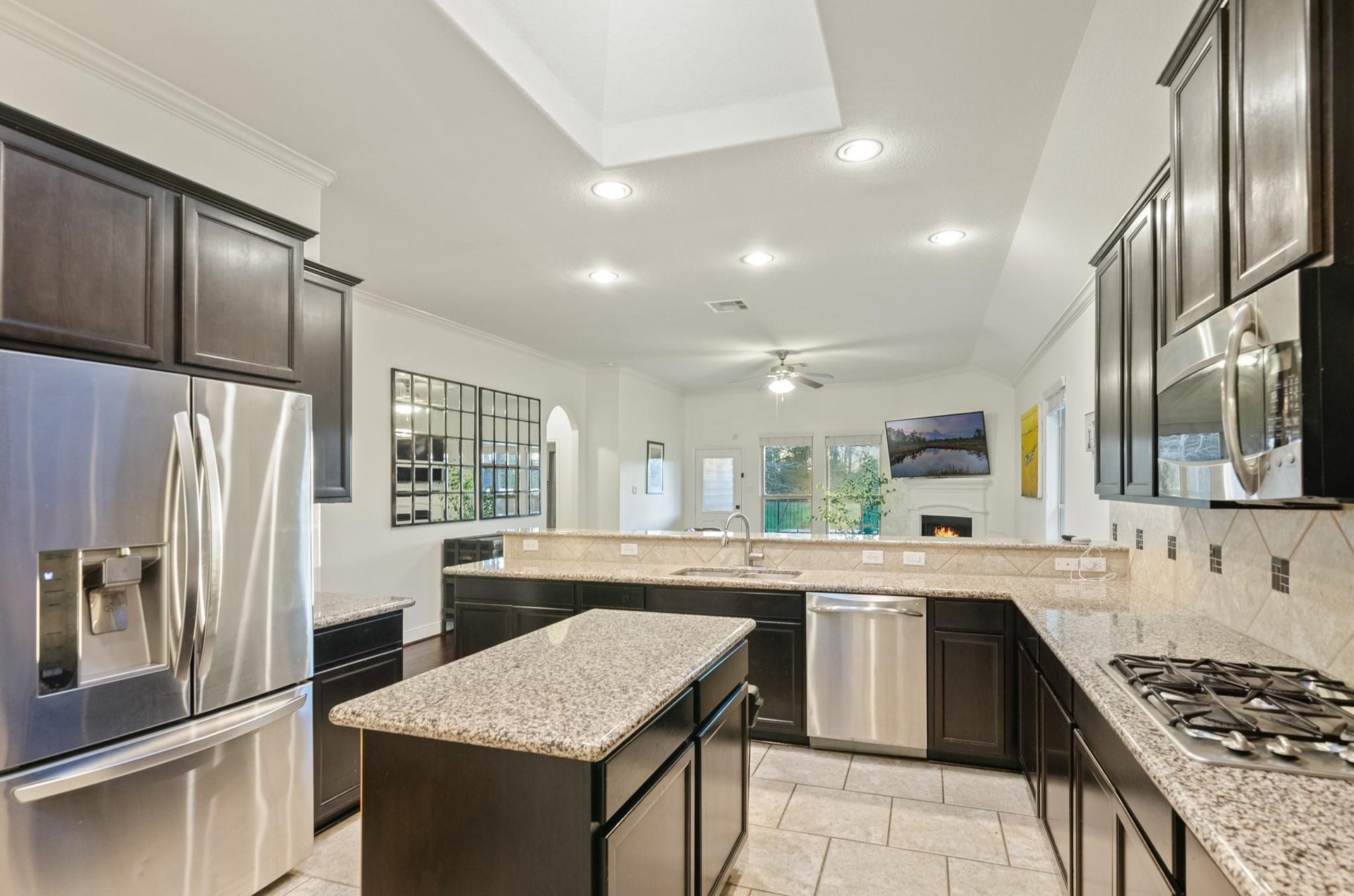 103 W Wading Pond Circle, Tomball, TX 77375 The raised breakfast bar overlooks the entire living area and fireplace, so the chef is always part of the conversation.