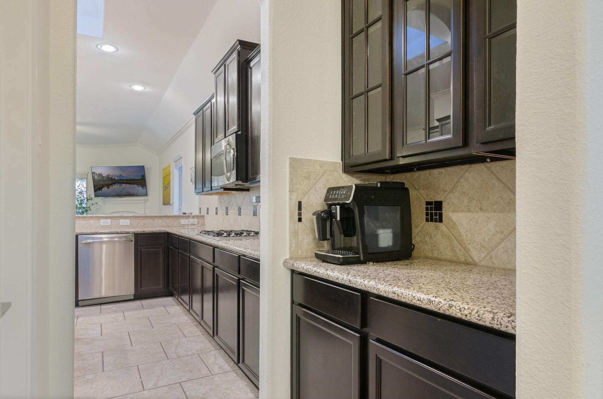 103 W Wading Pond Circle, Tomball, TX 77375 Conveniently positioned between the dining space and kitchen, this butlers pantry area provides extra counter space, dark-stained cabinetry, and glass-front upper cabinetsideal as a coffee bar, wine station, or staging area while entertaining.