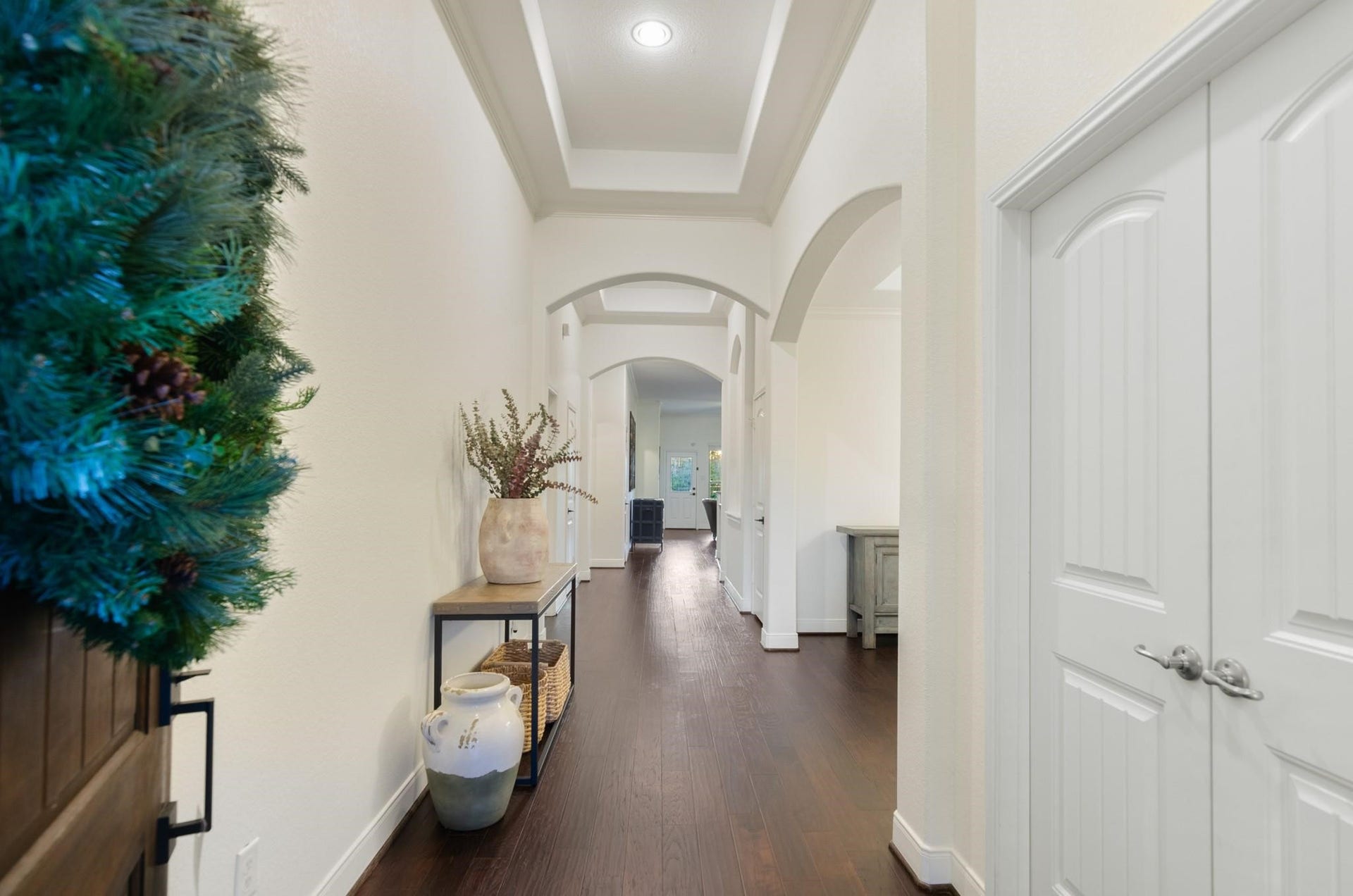 103 W Wading Pond Circle, Tomball, TX 77375 Step inside to a grand entryway highlighted by rich wood-look flooring, elegant tray ceilings, and classic architectural arches.