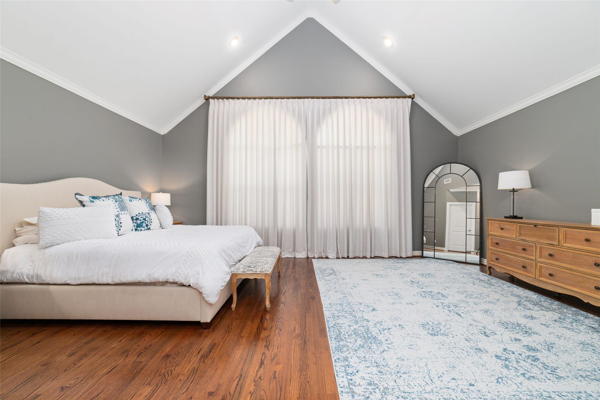 Expansive primary suite with soaring vaulted ceilings and beautiful hardwood floors.