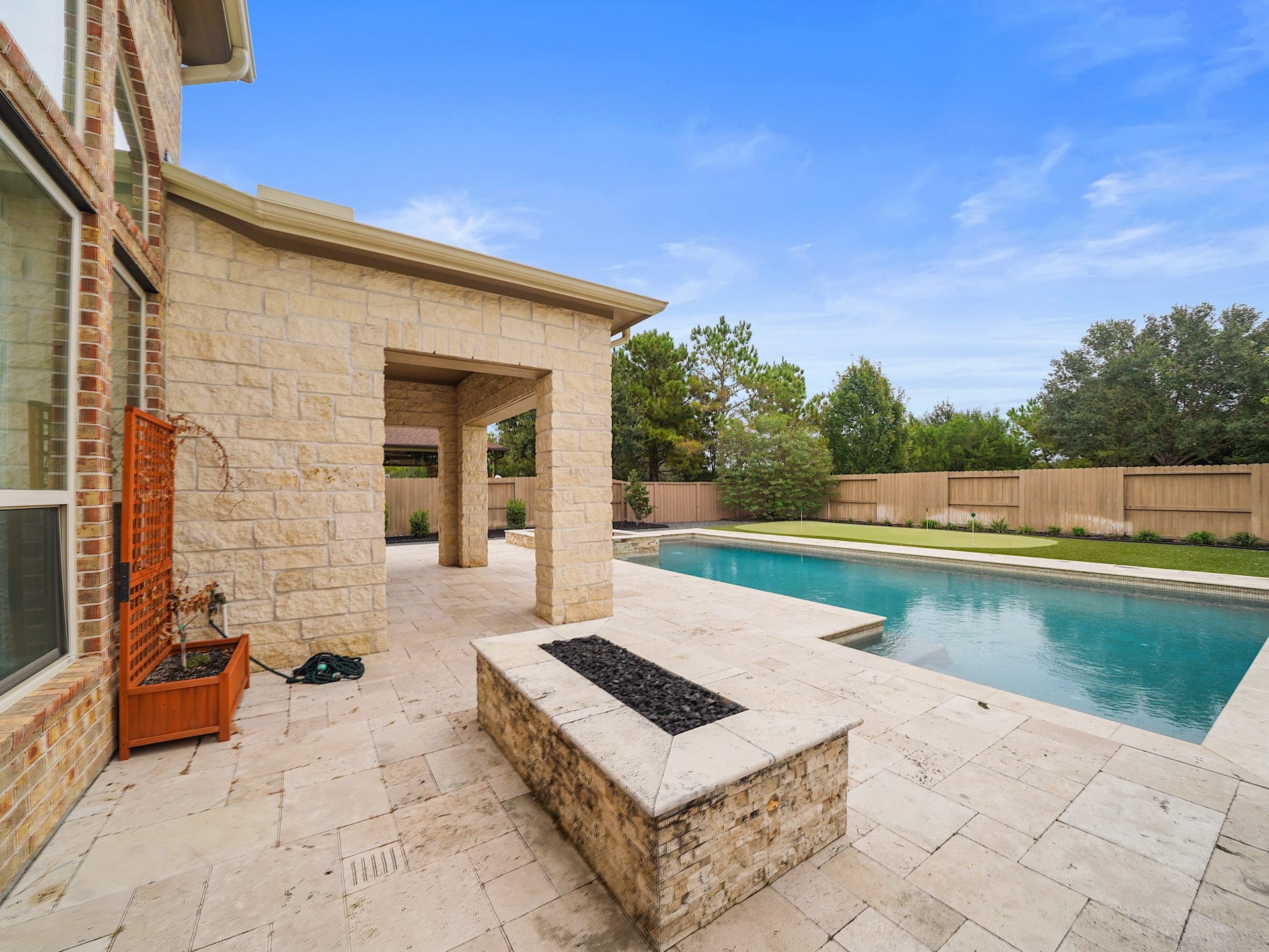 27710 Guthrie Ridge Lane, Katy, TX 77494 As evening settles in, the firepit creates an inviting place to gather, extending the backyards resort-style atmosphere well beyond sunset.