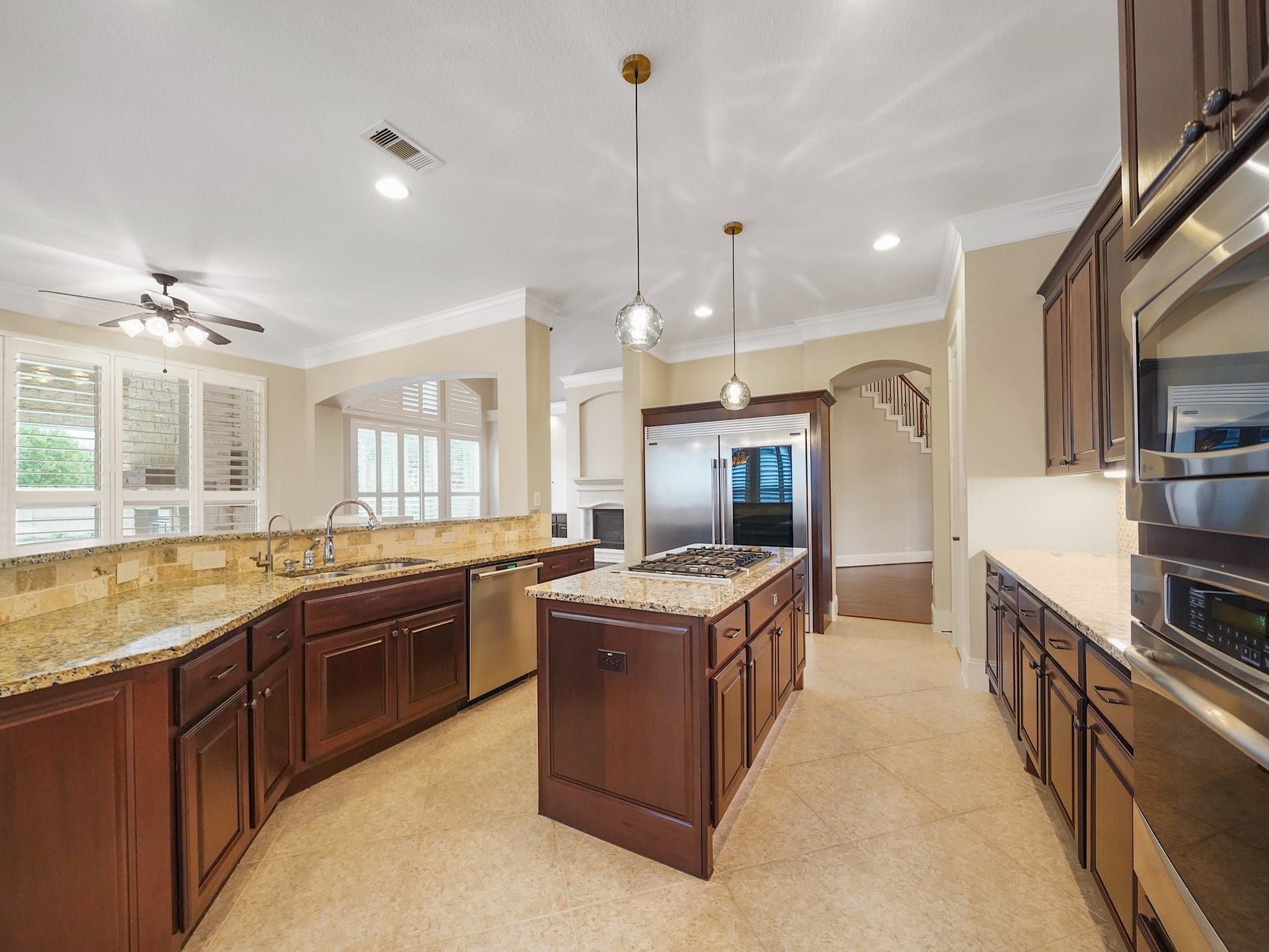 27710 Guthrie Ridge Lane, Katy, TX 77494 Rich cabinetry, granite counters, and a generous island with cooktop create a warm, functional kitchen that is as inviting for everyday meals as it is for entertaining.