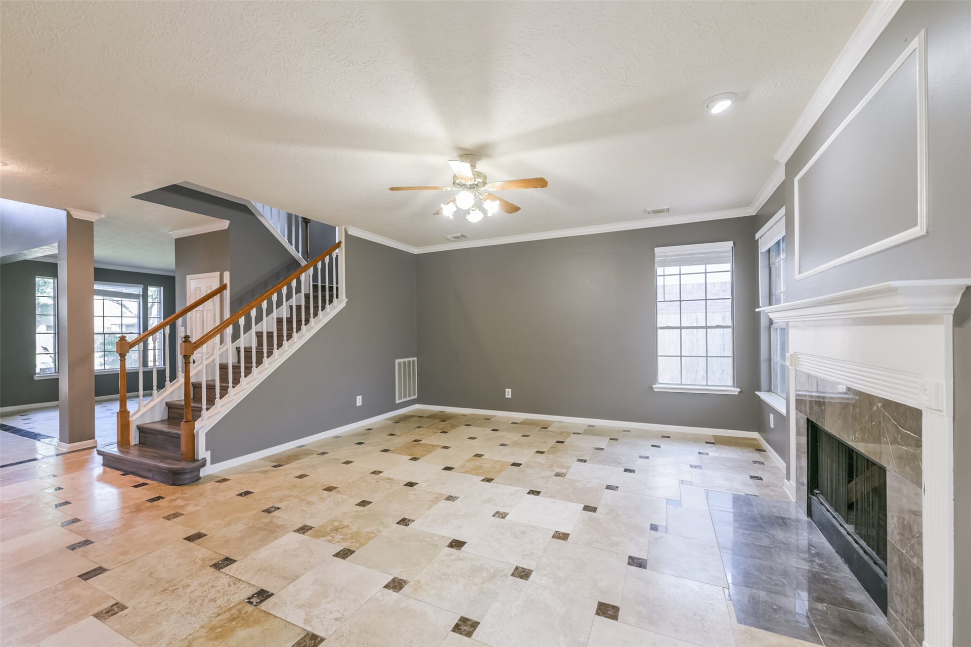 2509 S Mission Circle, Friendswood, TX 77546 Spacious family room with elegant tile flooring, a cozy fireplace, and abundant natural light, perfect for gatherings and relaxation.