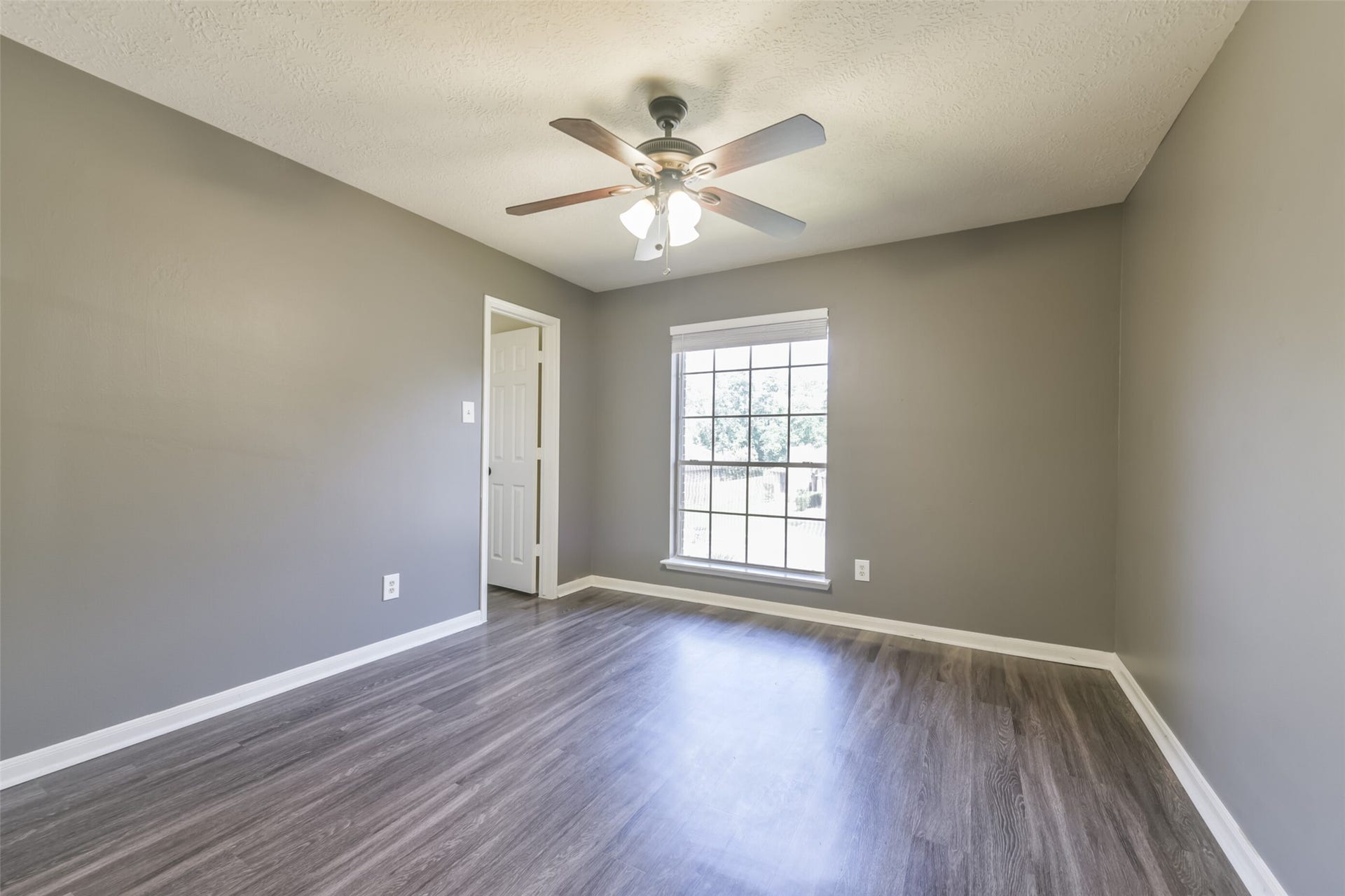 2509 S Mission Circle, Friendswood, TX 77546 Bright and inviting, this secondary bedroom boasts sleek flooring, fresh neutral tones, and abundant natural light through a large window.