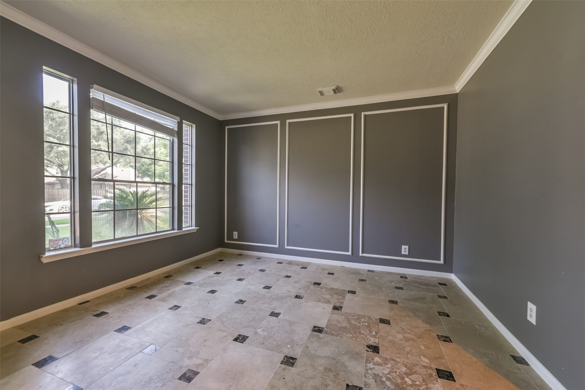 2509 S Mission Circle, Friendswood, TX 77546 Experience elegance in this formal living area, featuring large windows that flood the space with natural light, complemented by sophisticated wainscoting and a stylish tile floor.