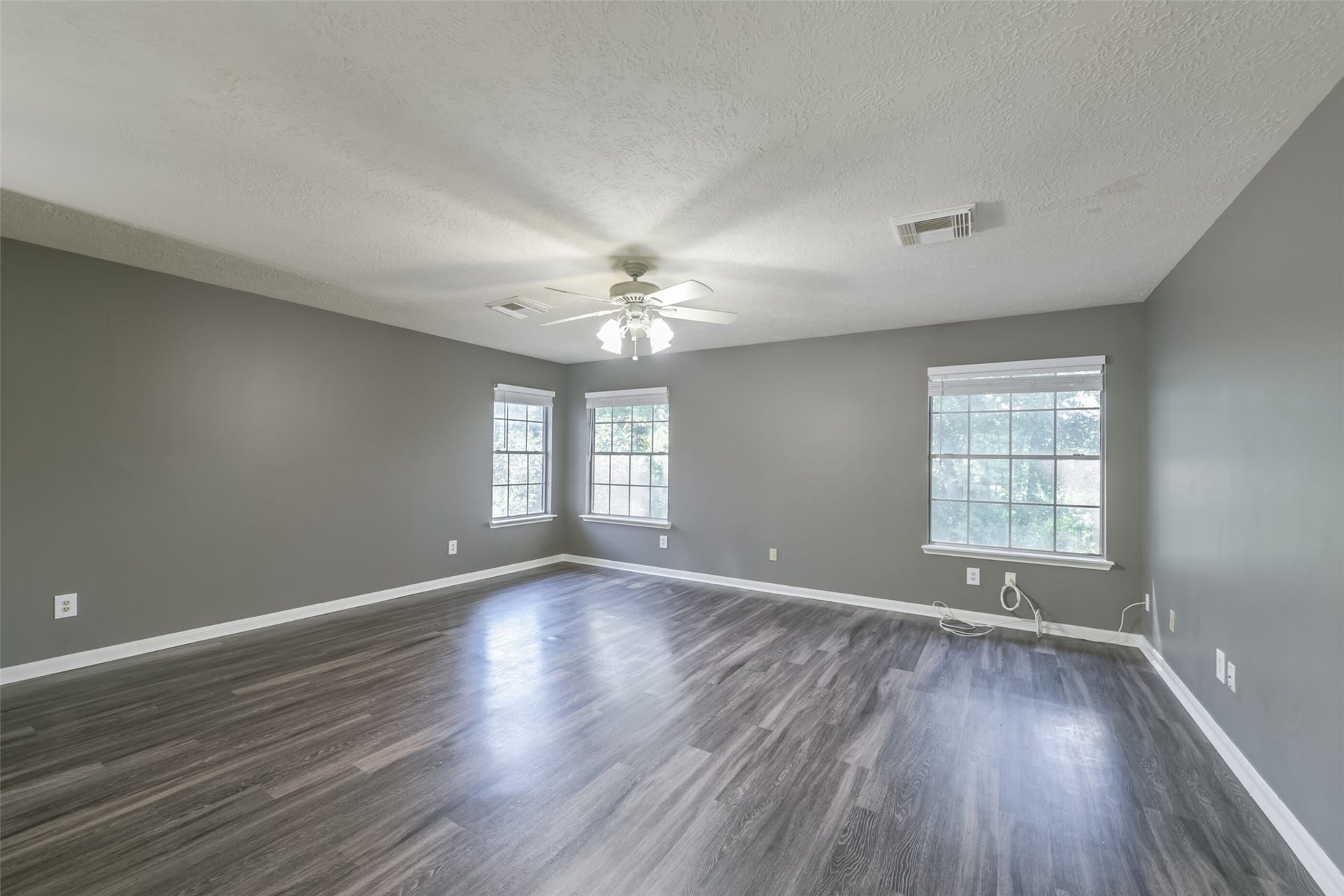 2509 S Mission Circle, Friendswood, TX 77546 Upstairs, discover a spacious gameroom featuring sleek wood flooring and abundant natural light, perfect for entertainment and relaxation.