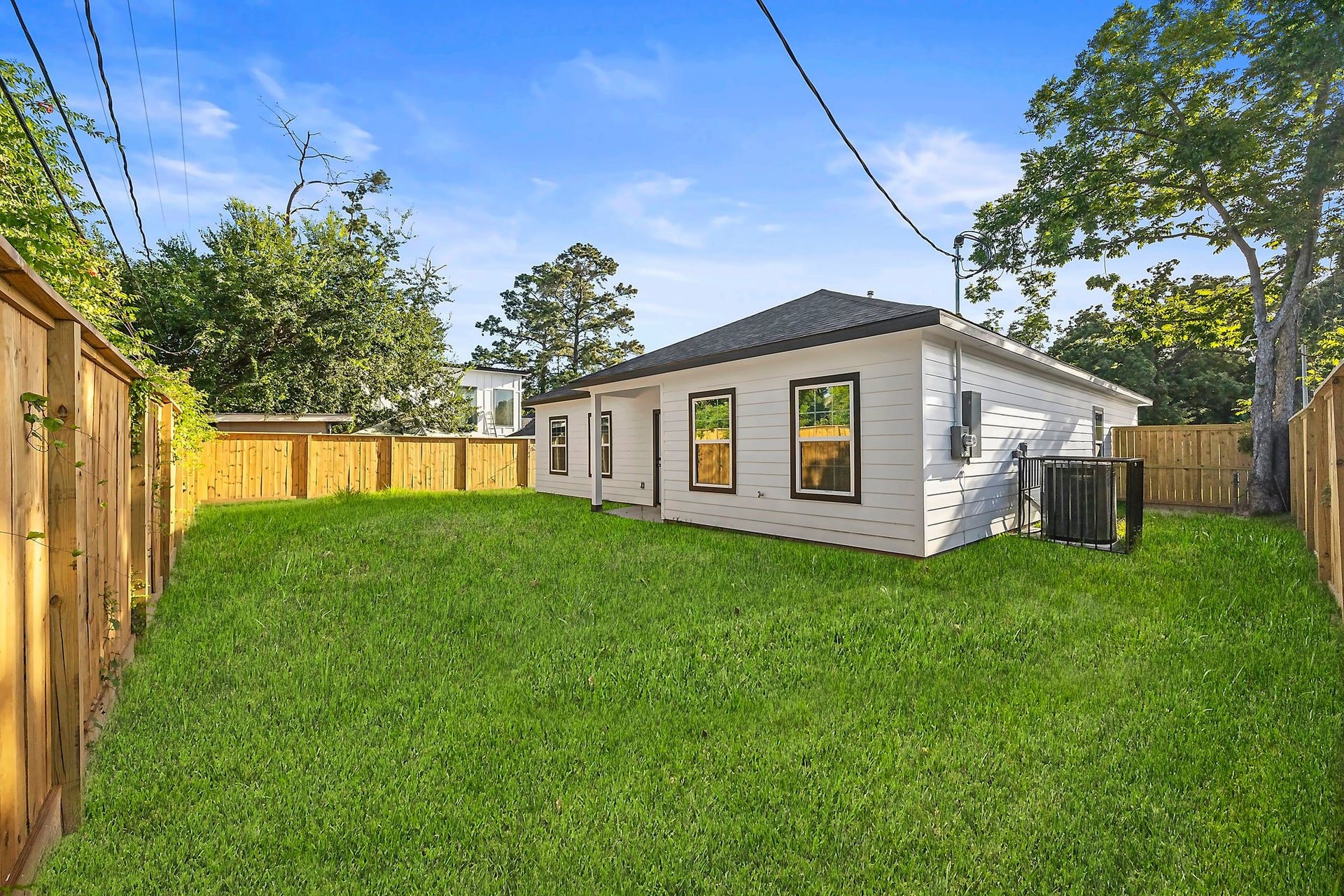 10426 Royal Oaks Drive, Houston, TX 77016 Spacious backyard with lush green lawn, surrounded by a wooden privacy fence, perfect for outdoor activities and gatherings.