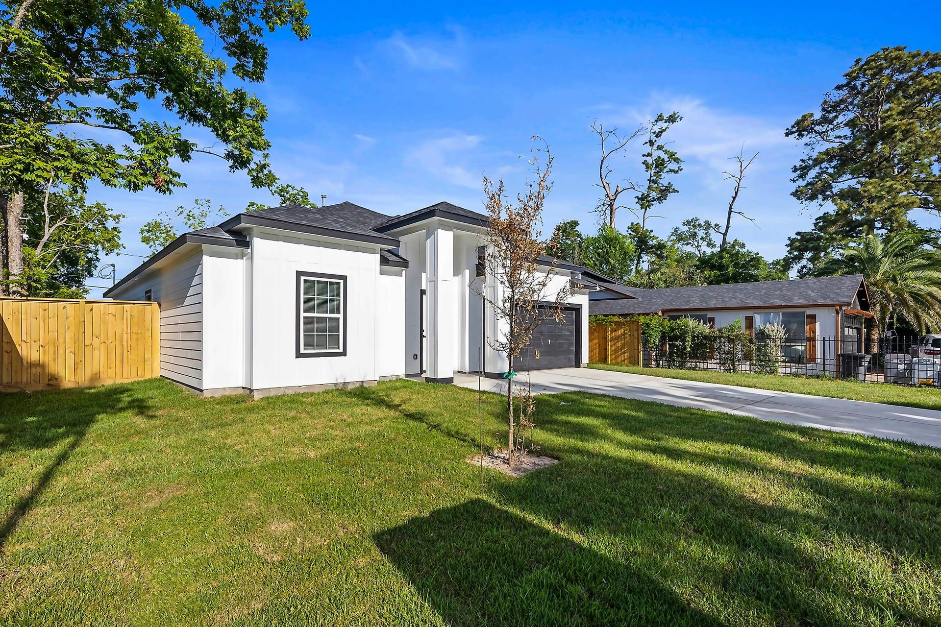 10426 Royal Oaks Drive, Houston, TX 77016 Modern single-story home featuring a sleek design, spacious driveway, and lush green lawn, all set in a serene neighborhood.