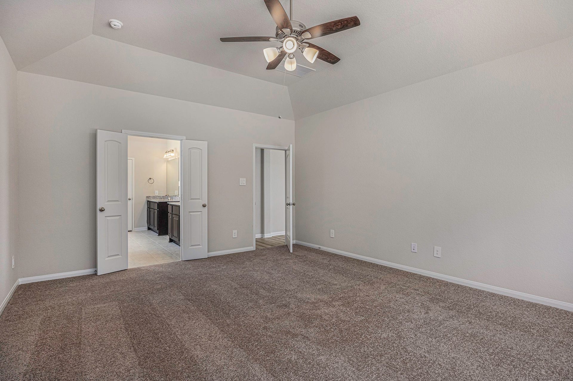 13264 Frio Falls, Conroe, TX 77303 Primary bedroom showing frenc doors to ensuite bath.