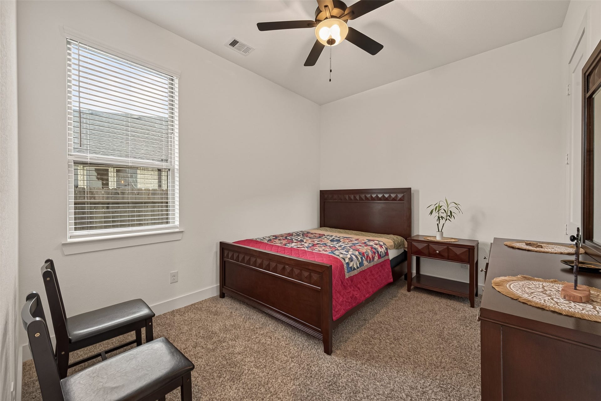 10730 Hidden Rock Drive, Missouri City, TX 77459 Spacious guest bedroom featuring plush, like-new carpeting, a modern ceiling fan, and an oversized window that fills the room with natural light. Conveniently located just off the family room, this suite includes an adjacent full bathroom, offering privacy and comfort for your guests.