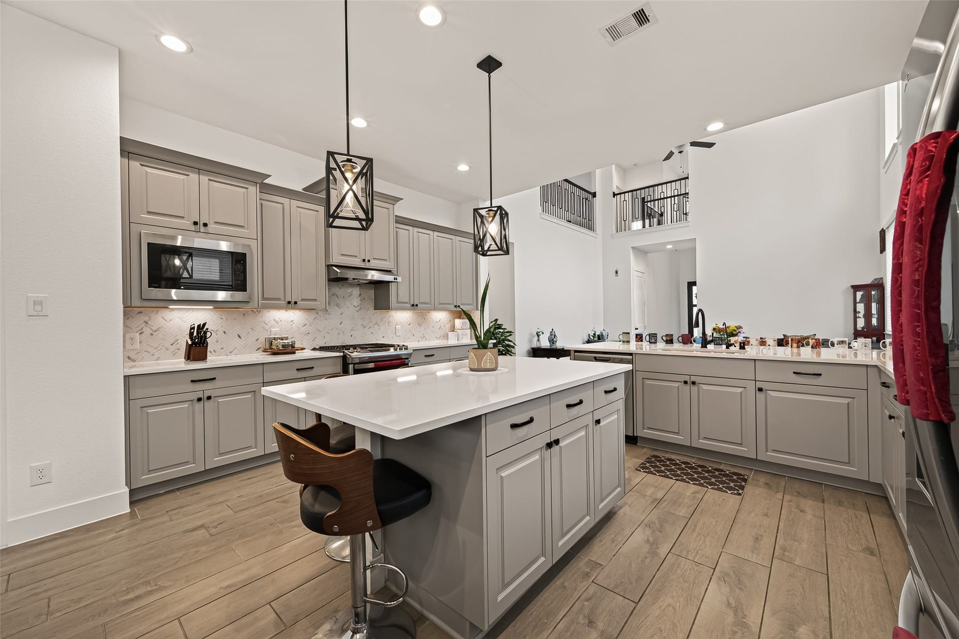 10730 Hidden Rock Drive, Missouri City, TX 77459 Open concept kitchen layout featuring a seamless transition to the upstairs catwalk, allowing for effortless communication and connectivity between levels.