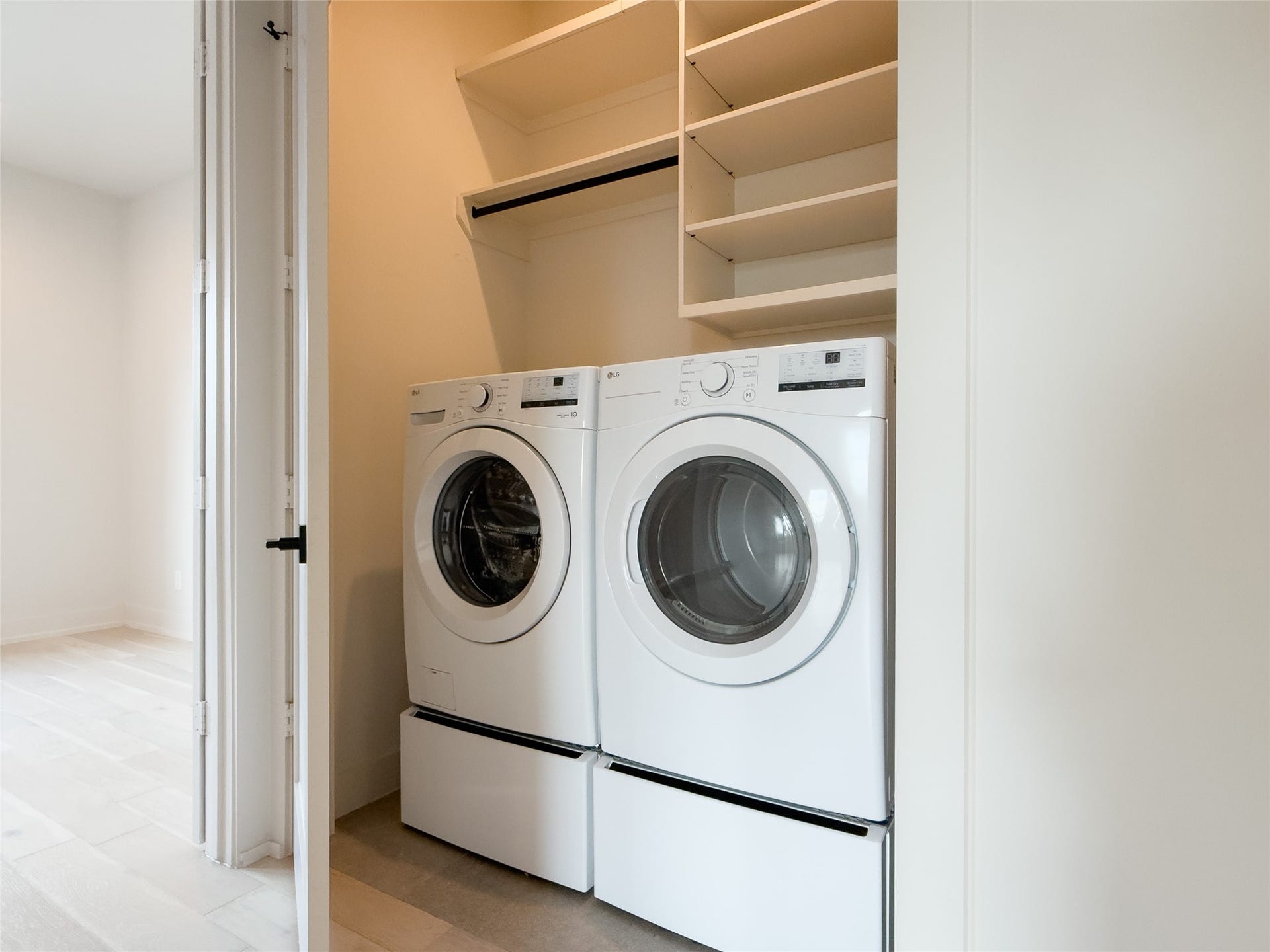 hall laundry closet w/more shelving, hanging rod; LG front-load washer & dryer included