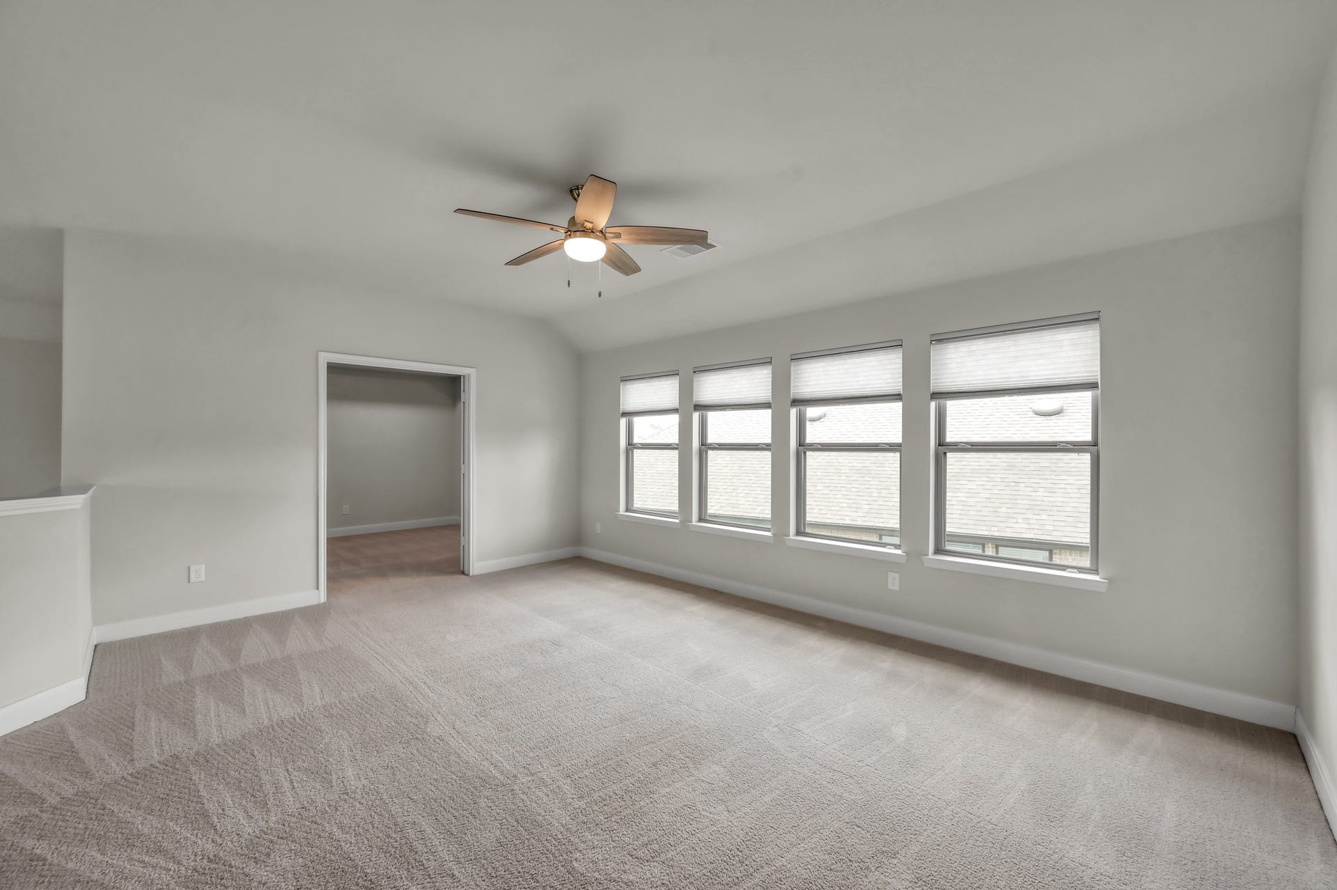 550 Chestnut Reef Court, Conroe, TX 77304 Spacious, bright game room with soft carpeting, multiple windows, and a clean, versatile layout.