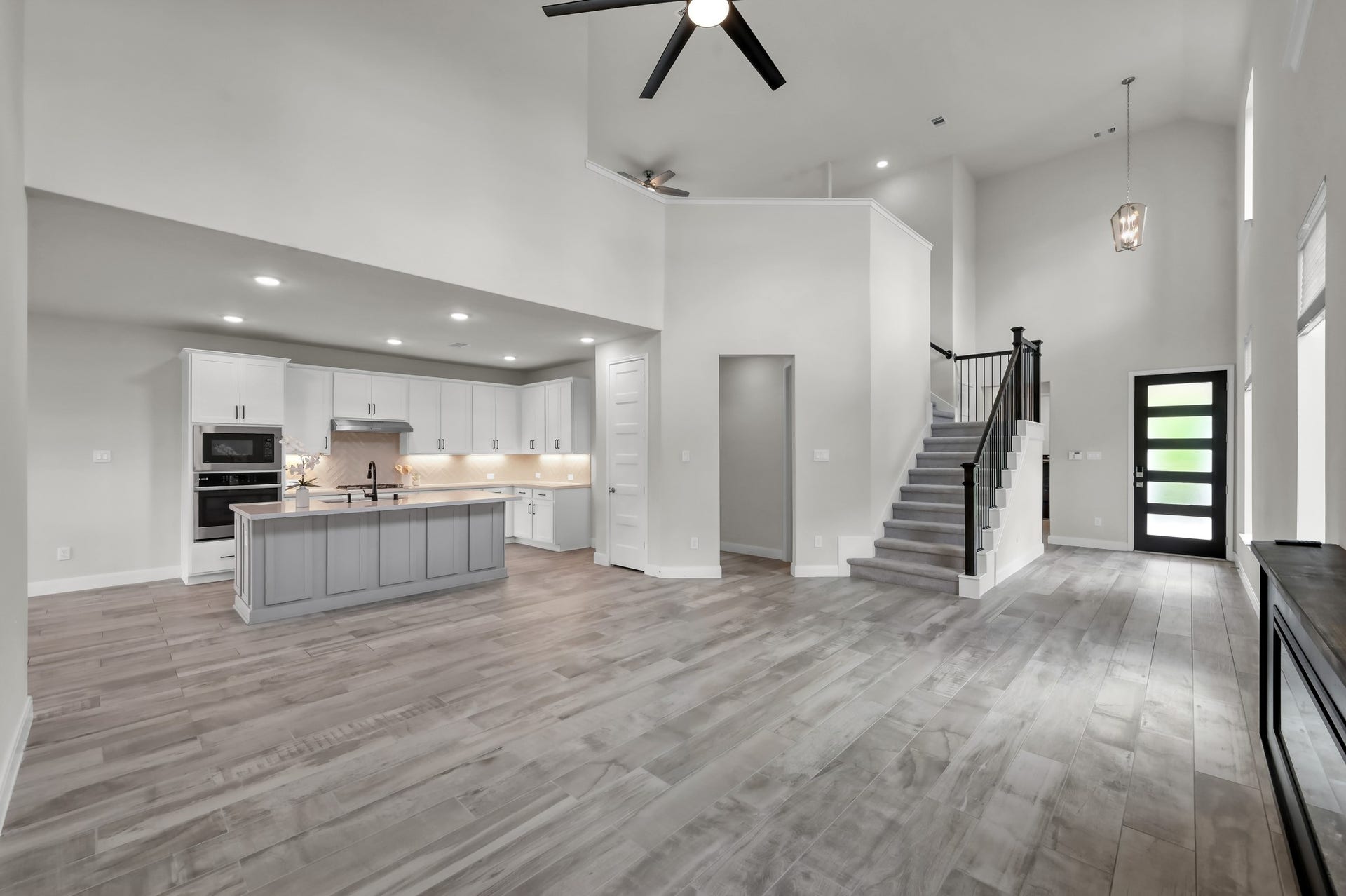 550 Chestnut Reef Court, Conroe, TX 77304 Expansive open layout with soaring ceilings, modern staircase, and seamless flow to the kitchen.