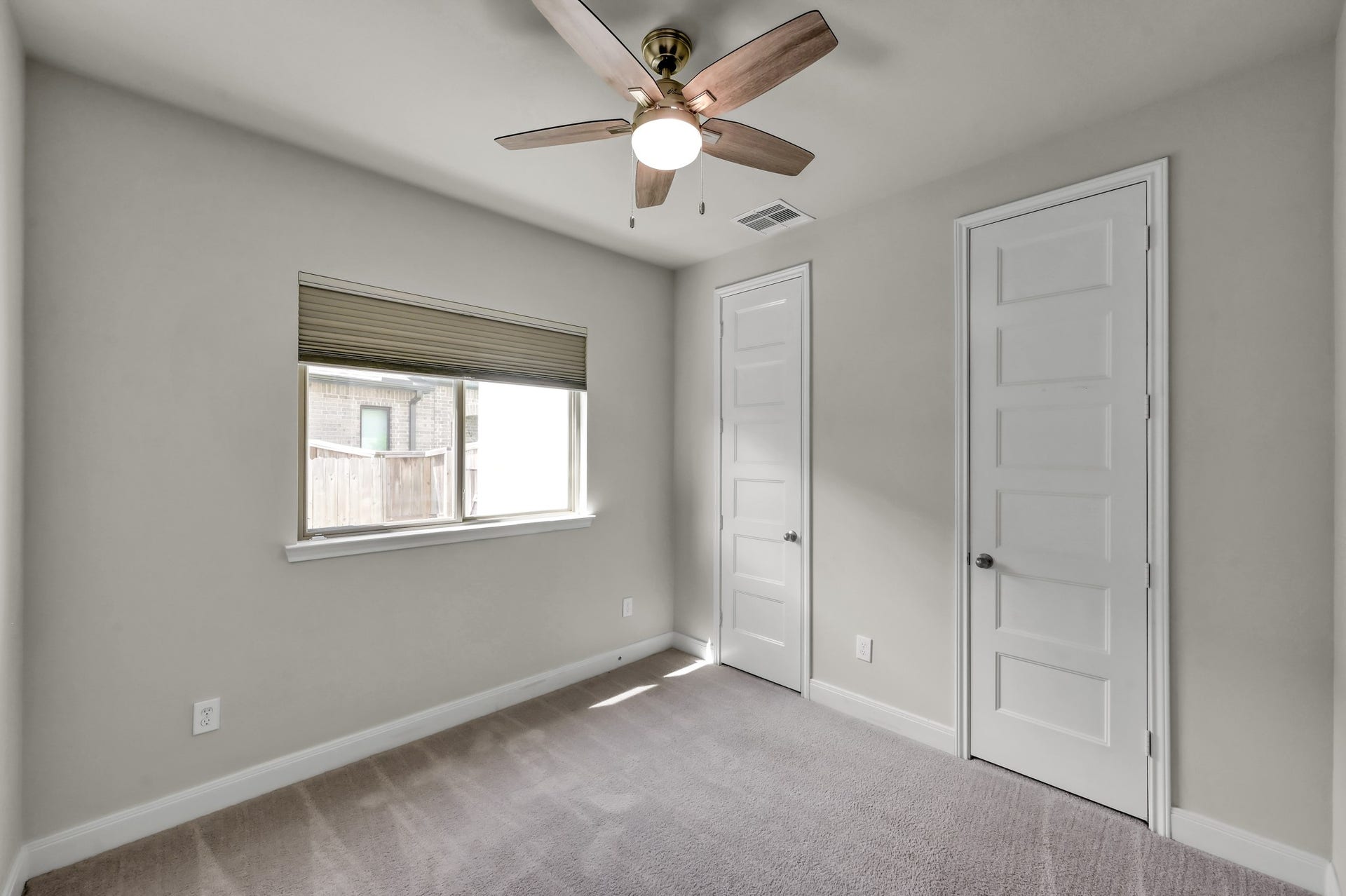 550 Chestnut Reef Court, Conroe, TX 77304 Secondary bedroom down with plush carpeting, ceiling fan, and ample closet space.