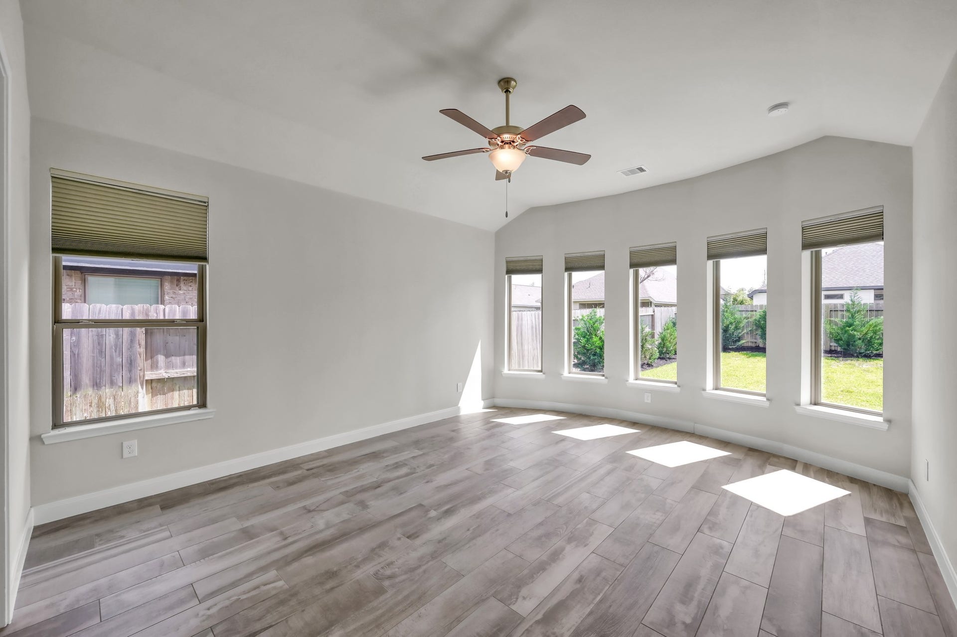 550 Chestnut Reef Court, Conroe, TX 77304 Spacious primary suite with wall of windows, abundant natural light, and serene backyard views.