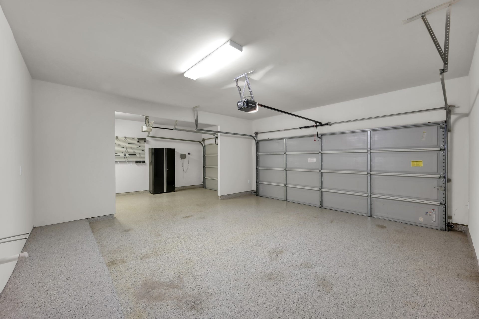 550 Chestnut Reef Court, Conroe, TX 77304 Oversized 3-car garage featuring durable epoxy flooring perfect for storage or hobbies.