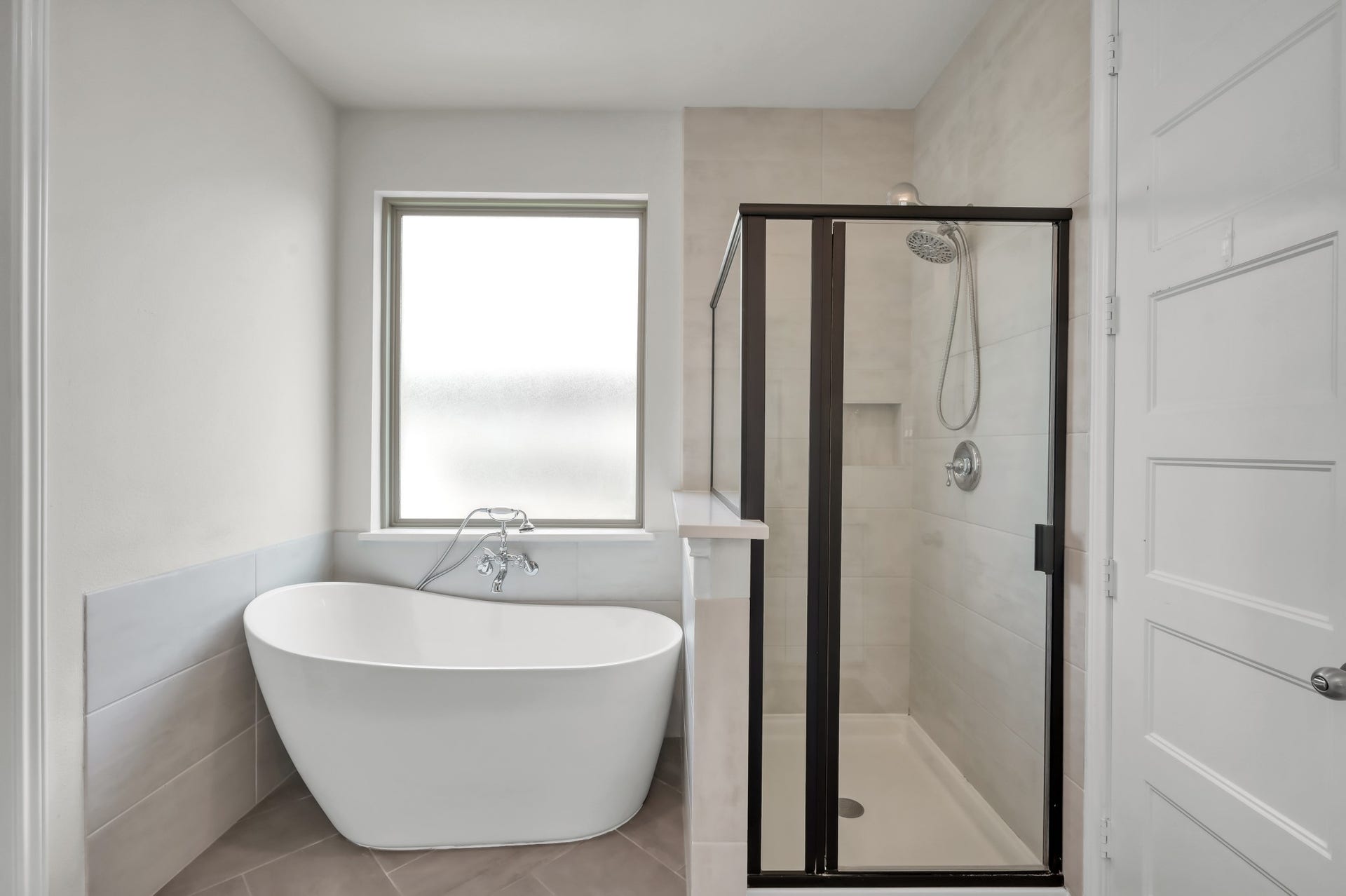 550 Chestnut Reef Court, Conroe, TX 77304 Spa-like primary bath with freestanding soaking tub and separate glass-enclosed shower.