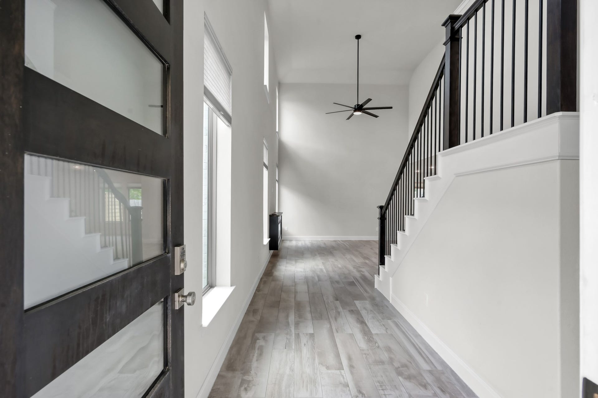 550 Chestnut Reef Court, Conroe, TX 77304 Grand entry with soaring ceilings, wood-look tile flooring, and a striking staircase.