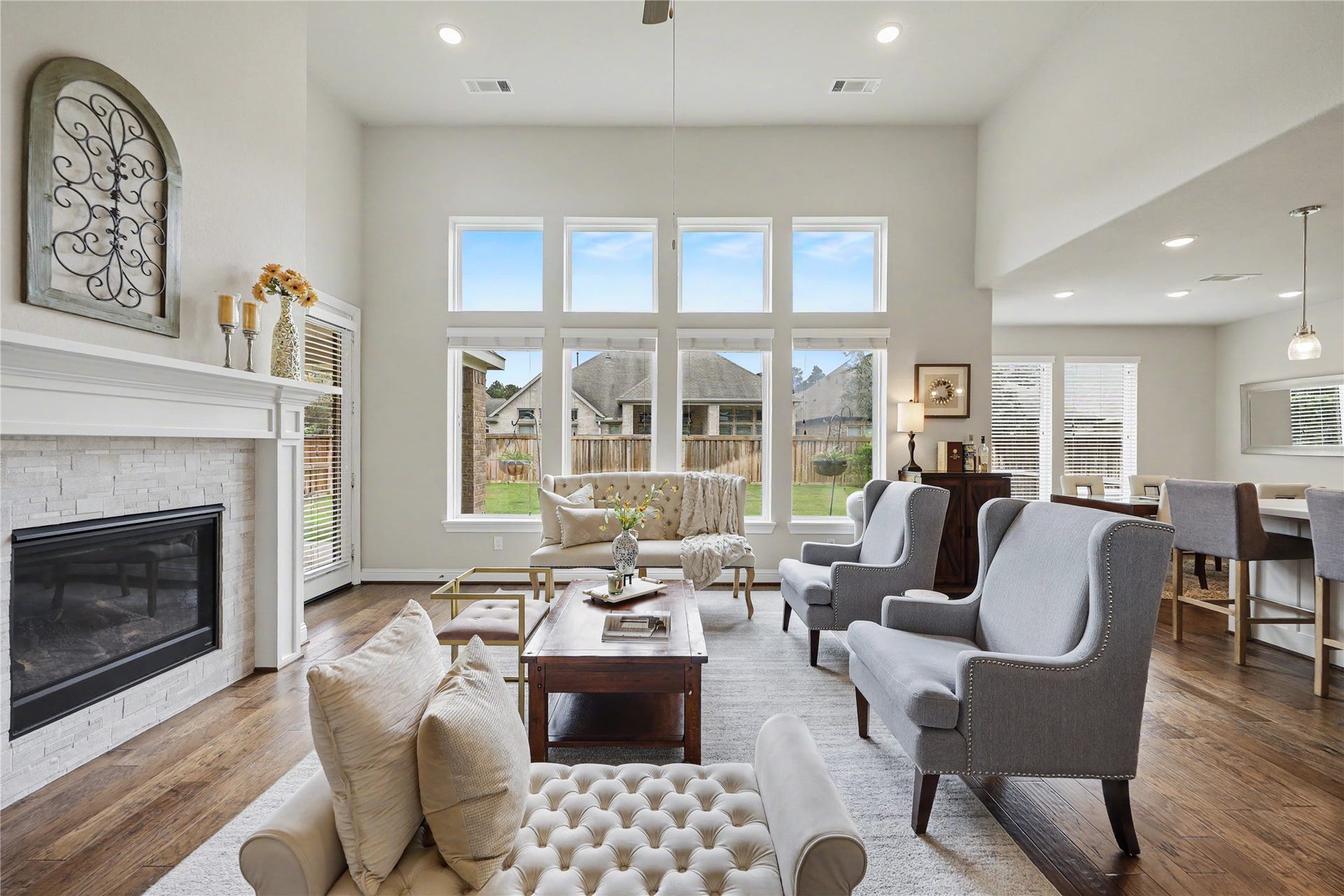 28216 Regal Wood Court, Spring, TX 77386 Two-story great room with fireplace, tall windows, and open sightlines to the kitchen and the backyard.
