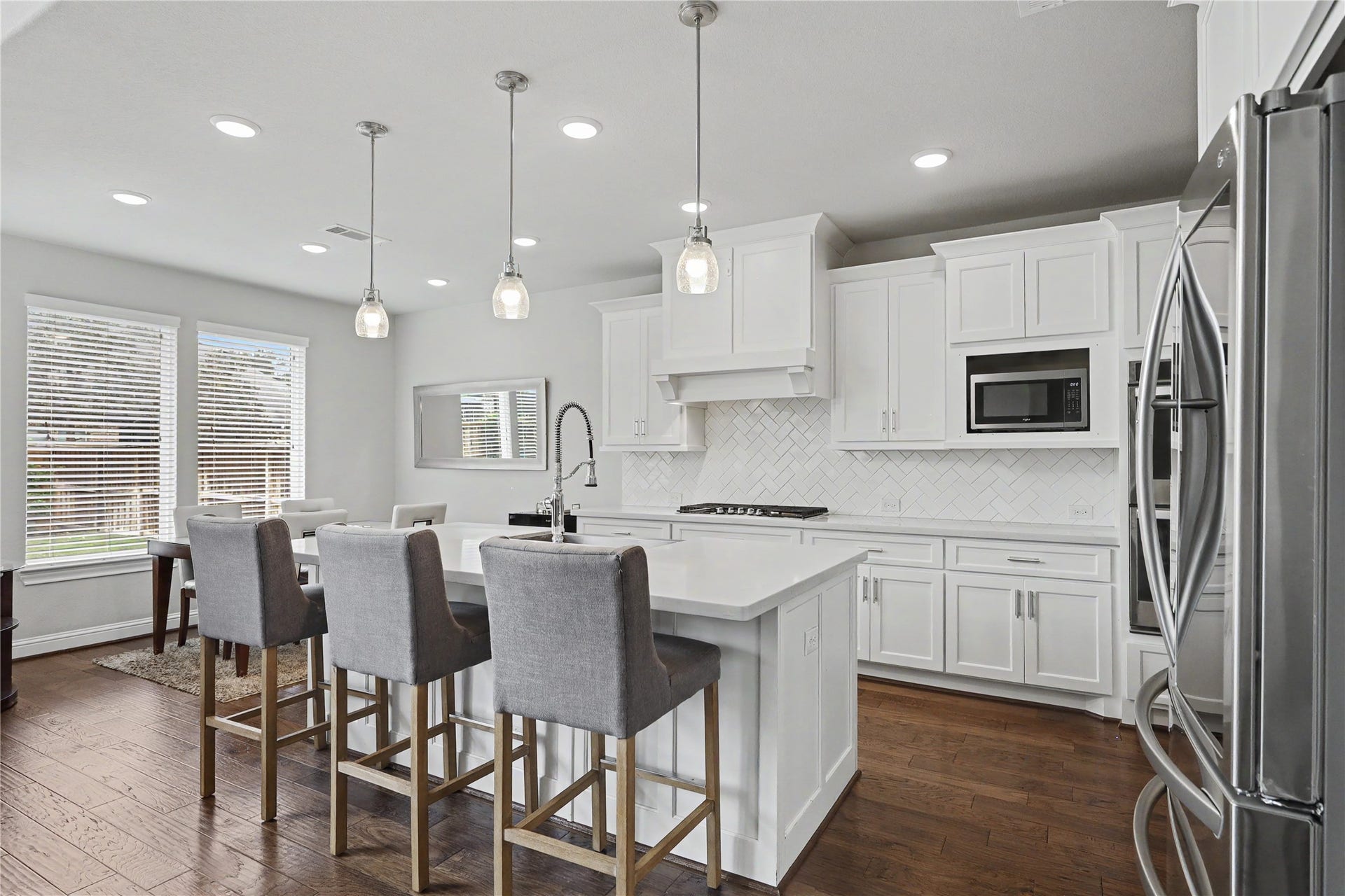 28216 Regal Wood Court, Spring, TX 77386 Additional kitchen view featuring island seating and adjacent living spaces.