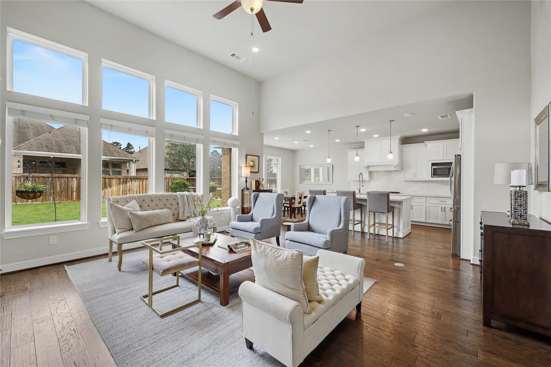 28216 Regal Wood Court, Spring, TX 77386 Two-story great room with soaring ceilings, fireplace, and a wall of windows overlooking the backyard.