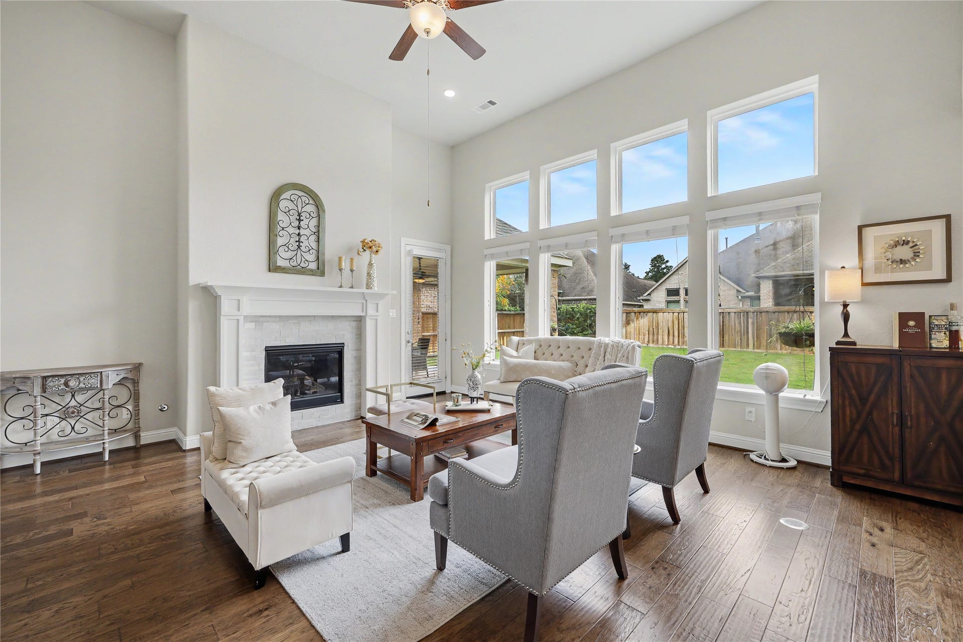 28216 Regal Wood Court, Spring, TX 77386 Two-story great room with fireplace, tall windows, and open sightlines to the kitchen.