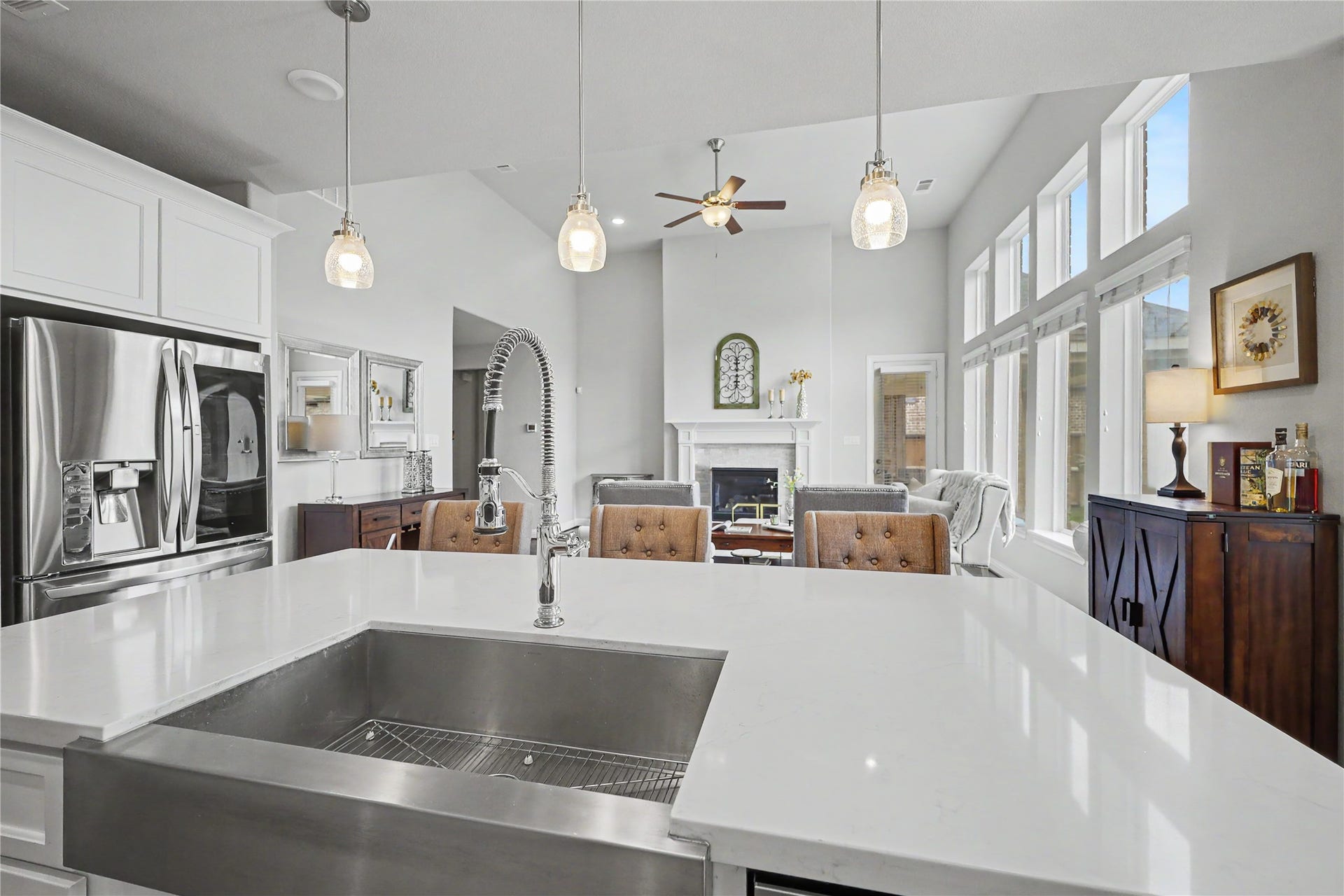 28216 Regal Wood Court, Spring, TX 77386 Great room view with soaring ceilings, tall windows, and fireplace from kitchen island.