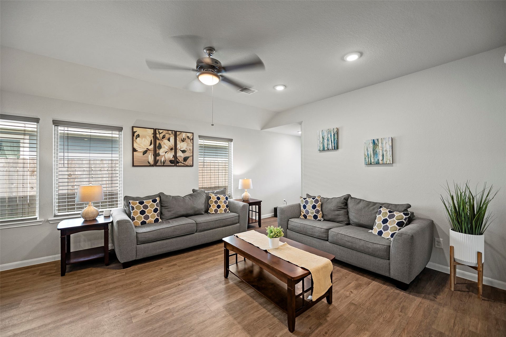 6938 Scarlet Sagebrush Street, Katy, TX 77449 This living room features abundant natural light, stylish laminate flooring, and an a ceiling fan.