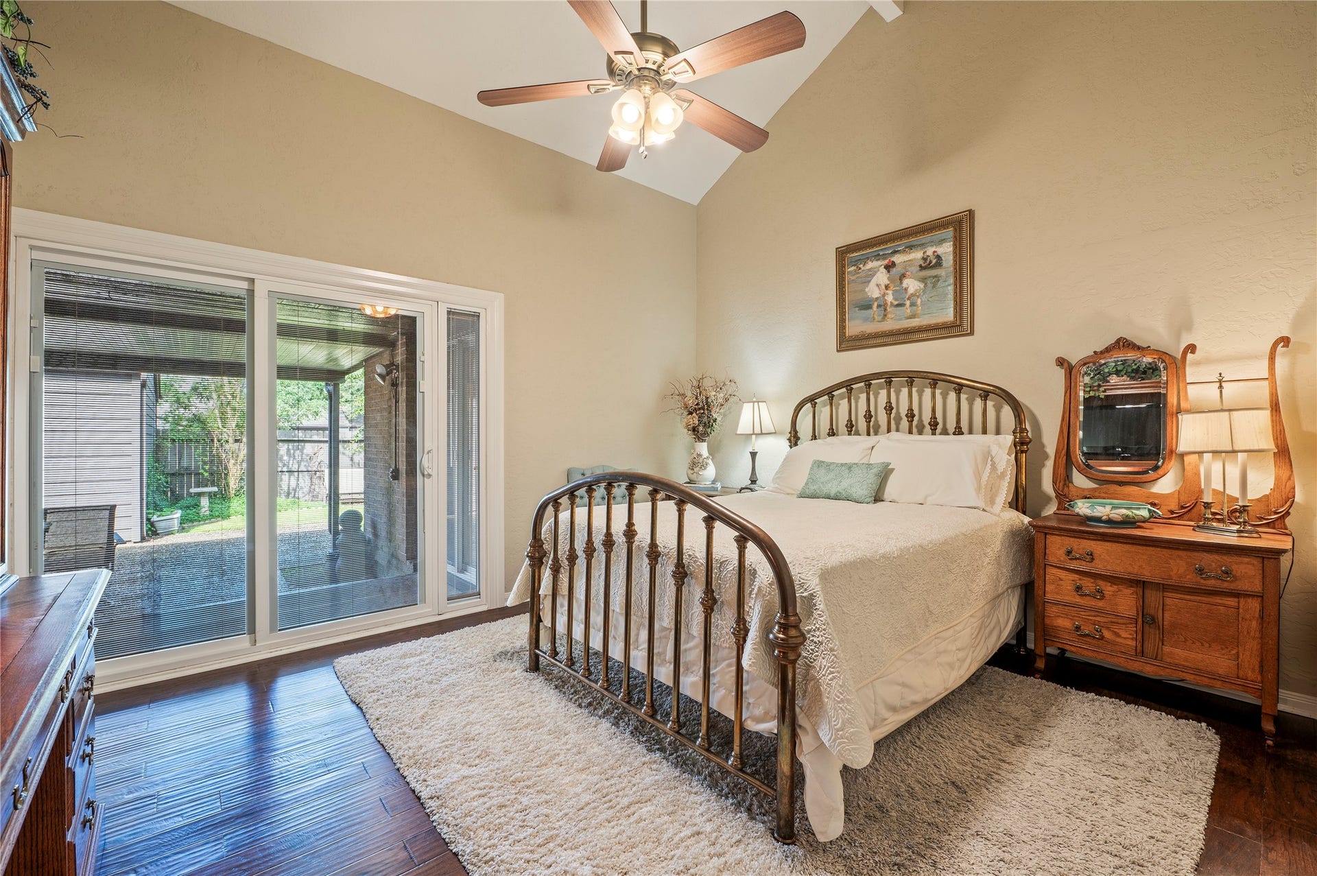 16530 Space Center Boulevard, Houston, TX 77058 Large primary bedroom with wood like flooring, high ceilings, and back patio access.