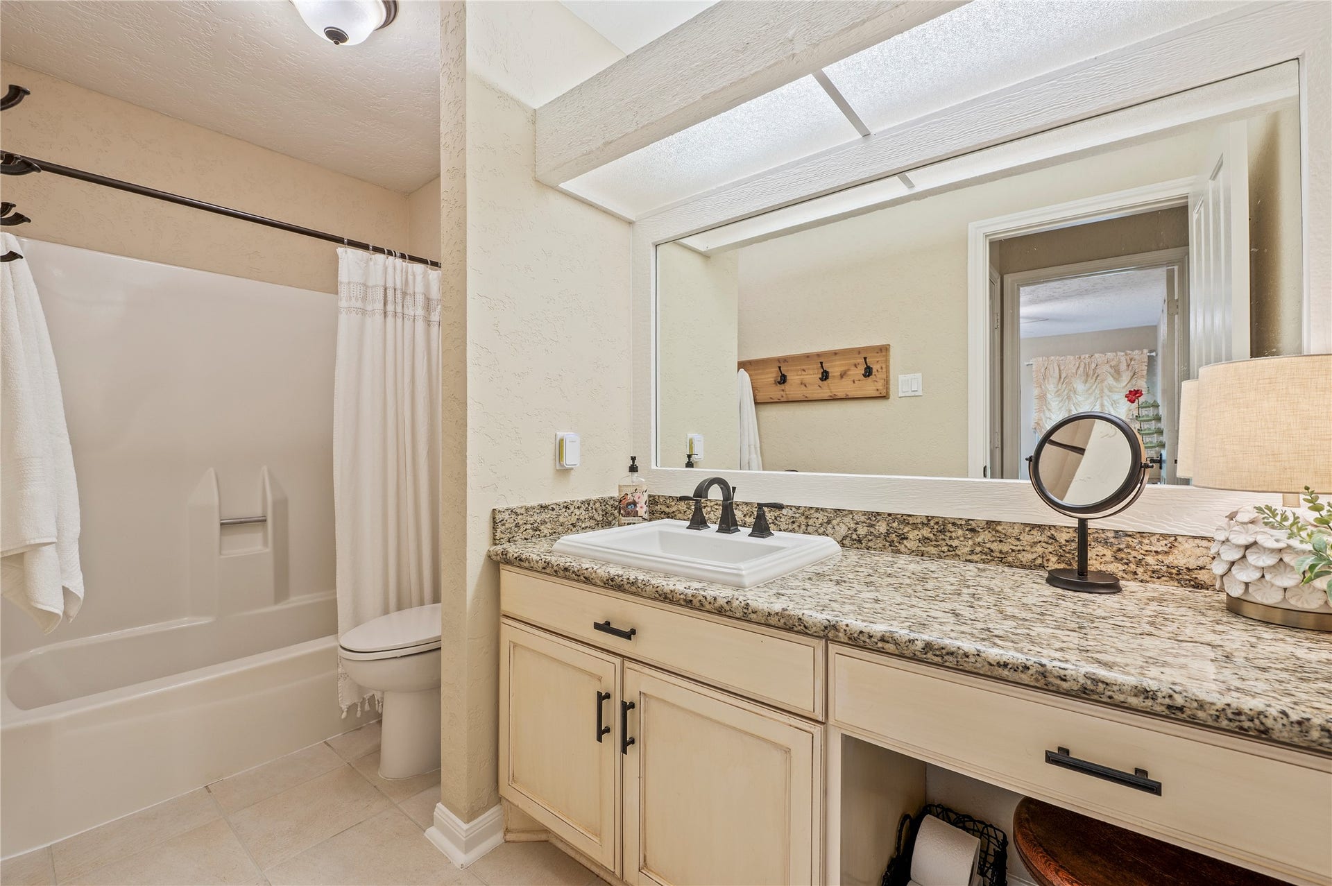 16530 Space Center Boulevard, Houston, TX 77058 Full sized spare bath with granite counter tops, tile flooring, and shower/tub combo.