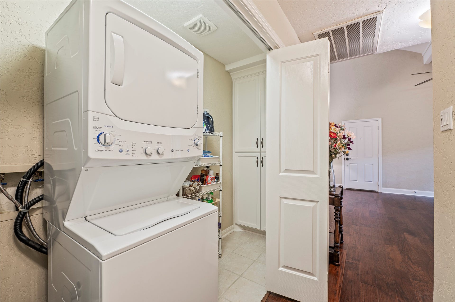 16530 Space Center Boulevard, Houston, TX 77058 Large utility space in the hallway with built in cabinets and shelving. Stackable washer/dryer.