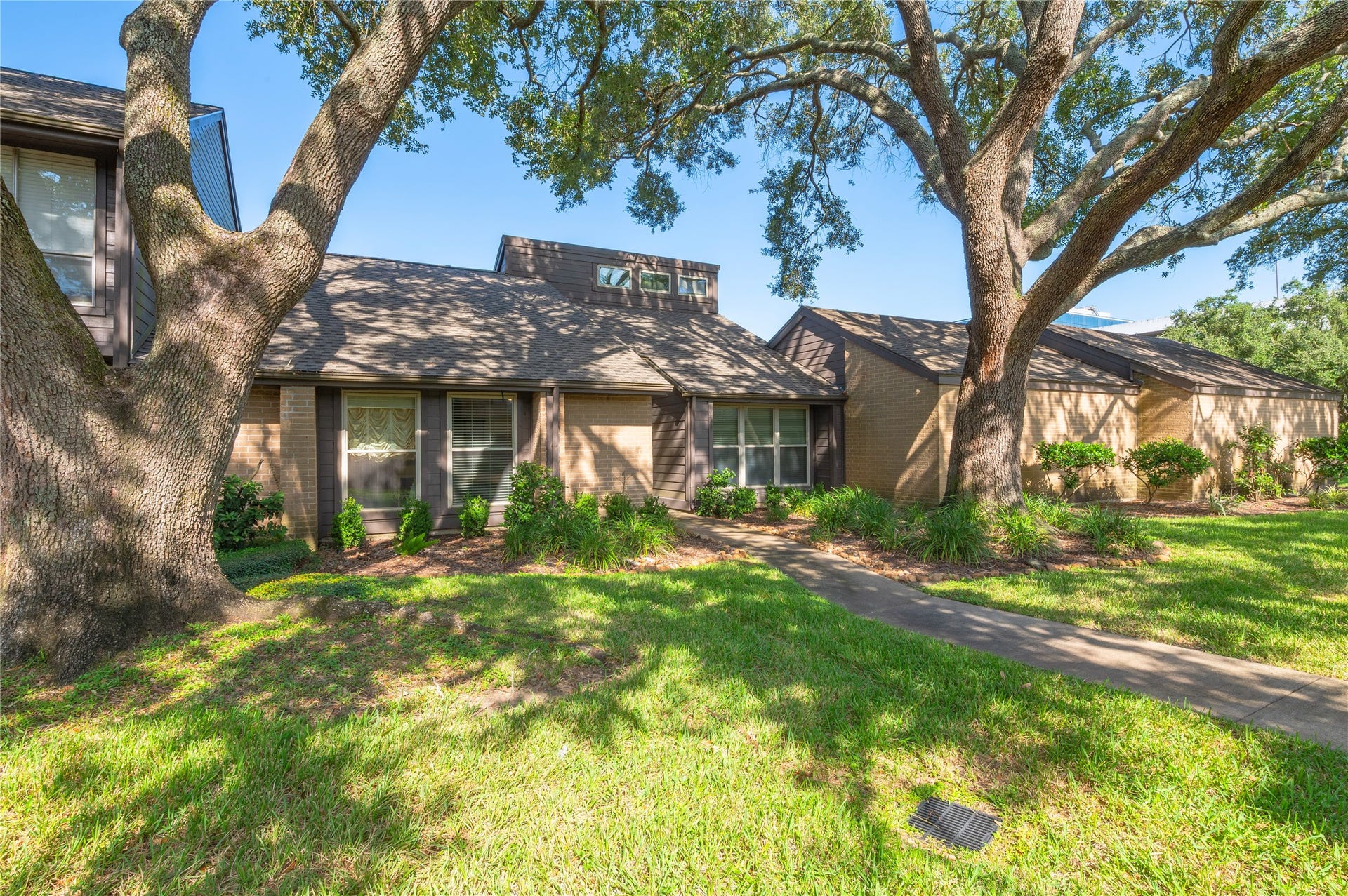 16530 Space Center Boulevard, Houston, TX 77058 Large green space in front of the home with shade from oak trees.