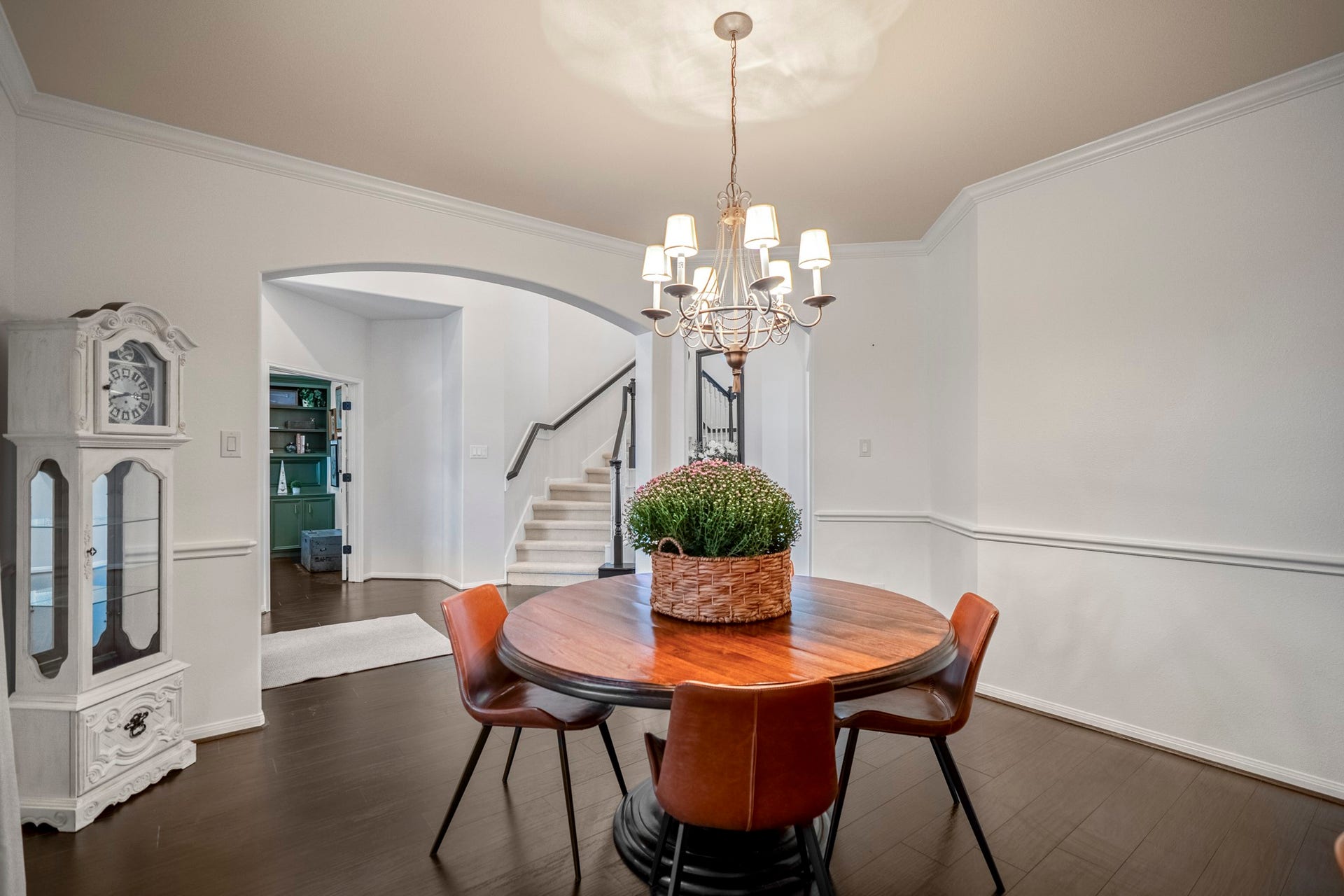 Framed by a classic arched doorway and elegant chair rail molding, the space flows with ease into the surrounding home.
