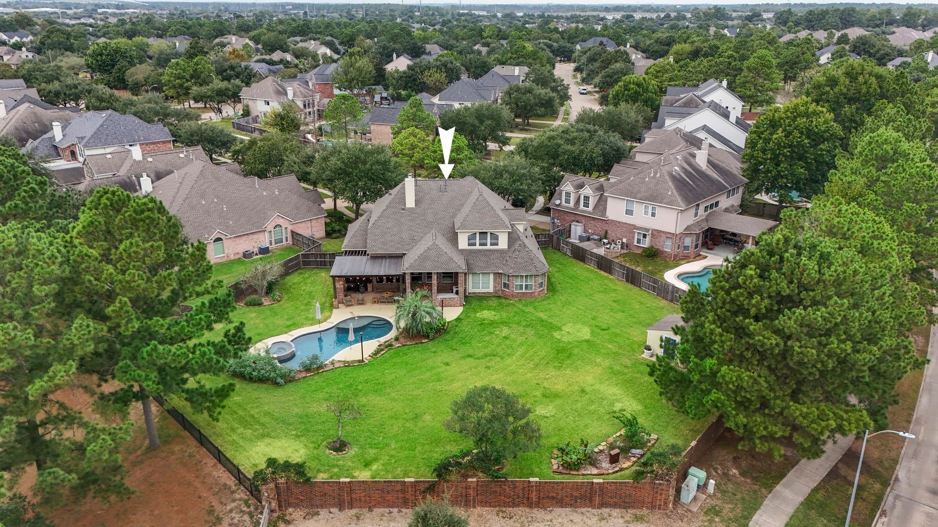 An aerial view showing one section of the fence line has a brick fence, whilst the golf course side is a wrought iron fence.