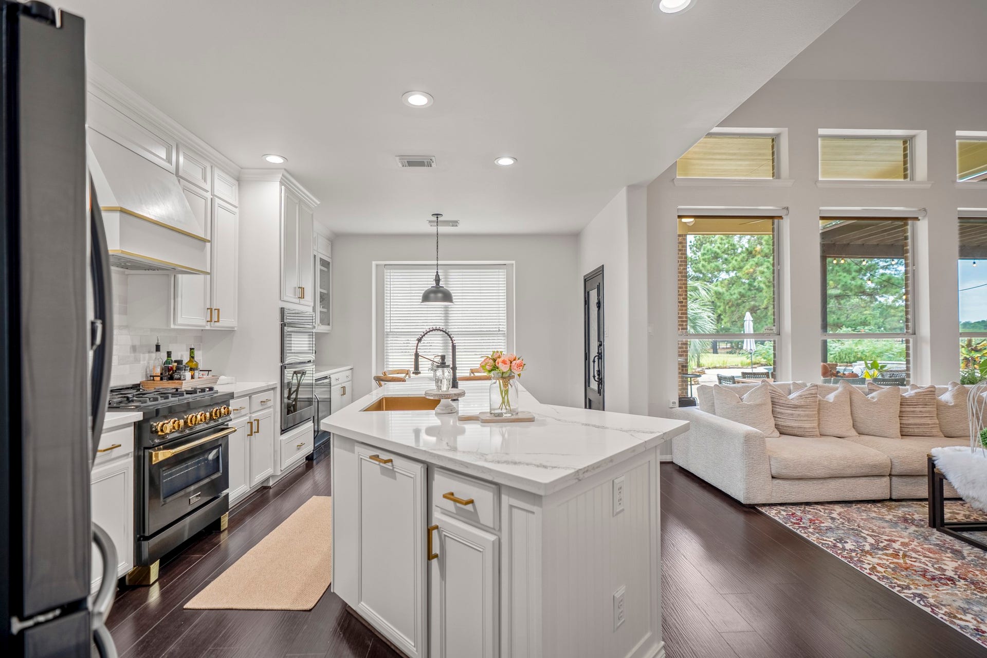 The gourmet kitchen offers high-end features; wall ovens, a built-in microwave, ZLINE four-burner gas range, designer hardware, gooseneck faucet, and custom vent hood trimming.