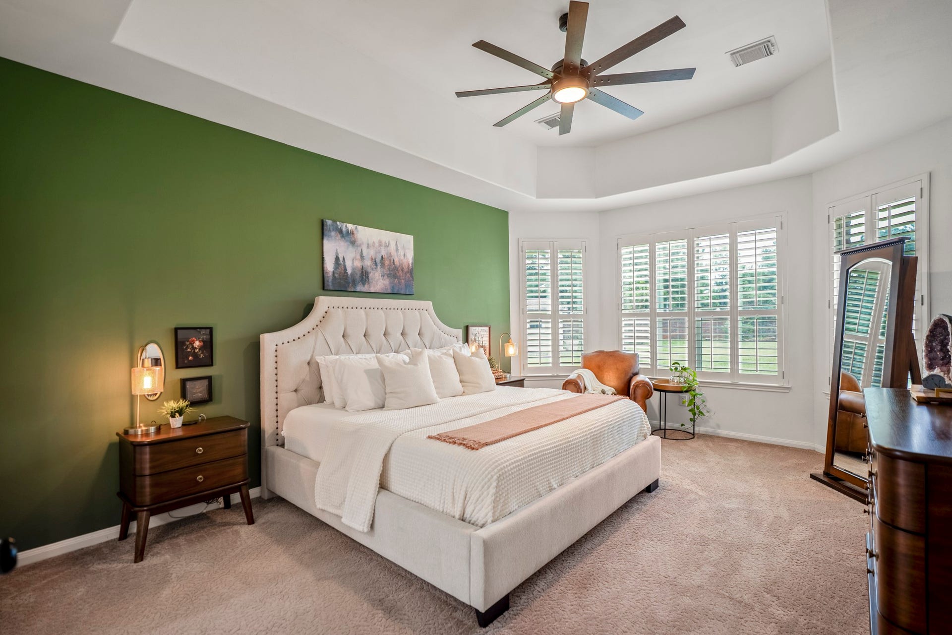 The primary suite has a large trey ceiling with large ceiling fan, a bay window with plantation shutters with wonderful views of the backyard.