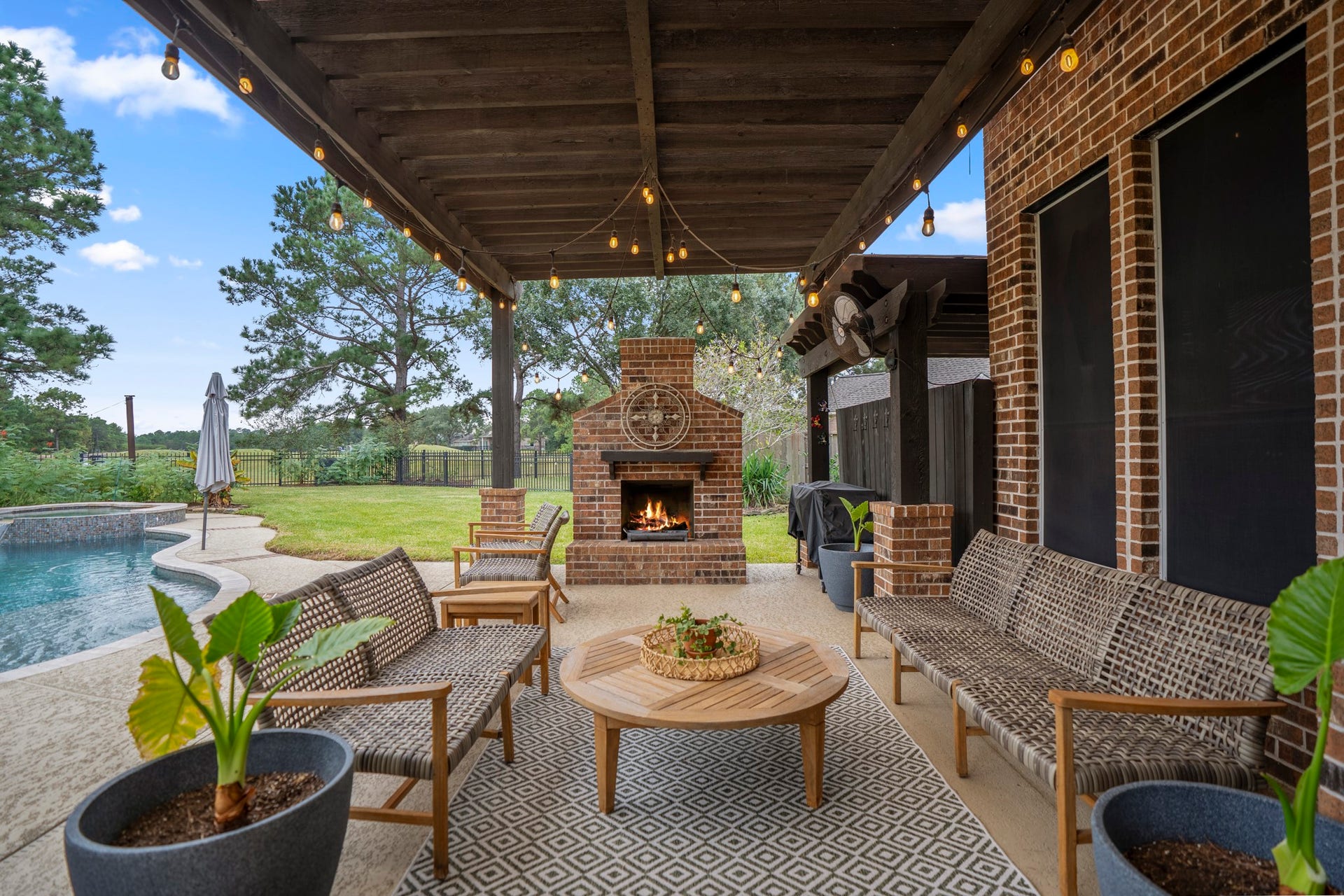 Spend relaxing evenings under the pergola accented by festive bistro lighting, which anchors a cozy freestanding brick fireplace, while taking in spectacular views of the golf course, sparkling in-ground pool, spa and sprawling, private green lawn framed by mature trees.