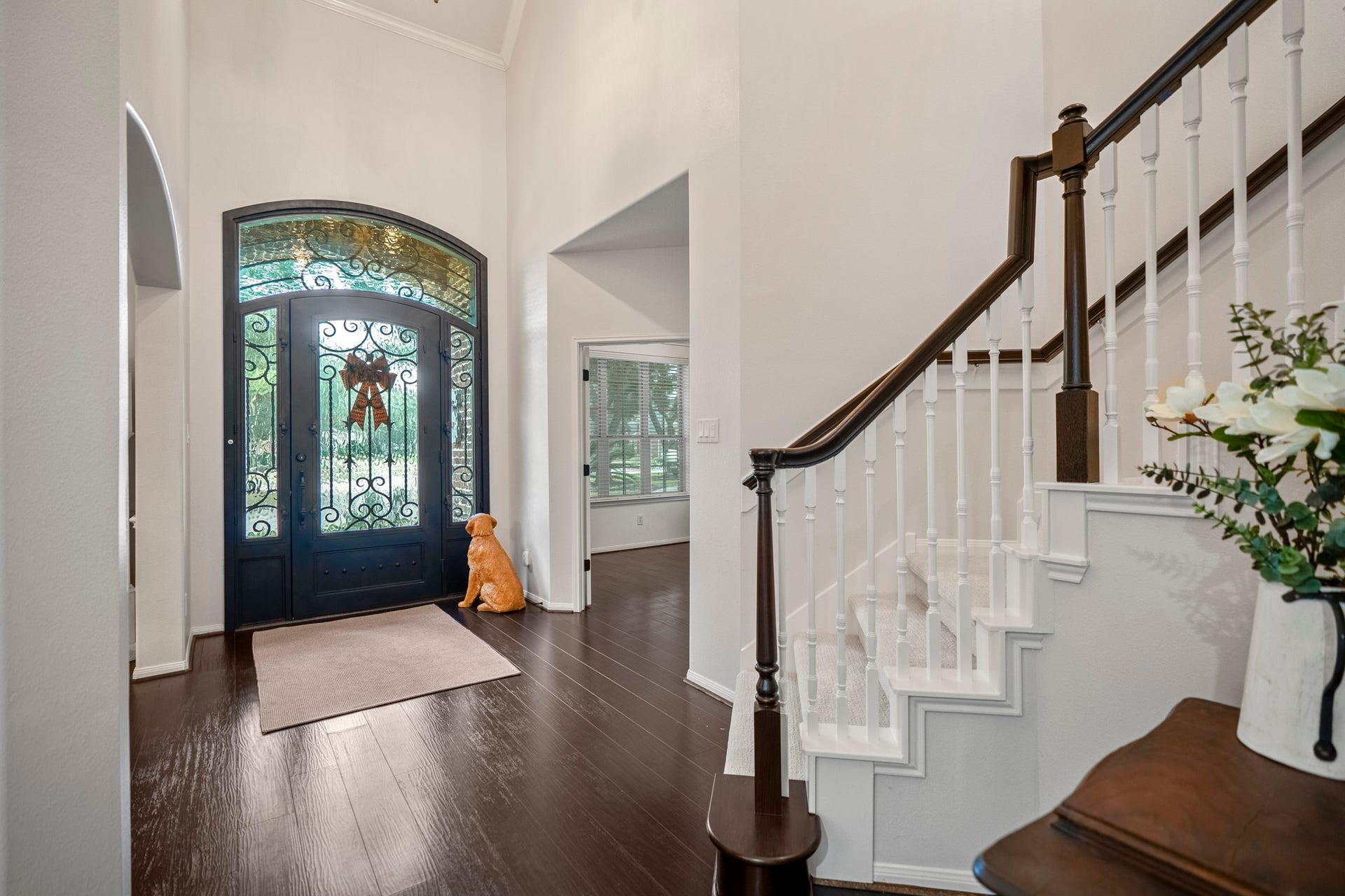 A breathtaking entrance that sets the standard for the entire home, with spectacular custom front door, featuring intricate leaded-glass detailing, and magnificent arched transom window that floods the foyer with natural light.