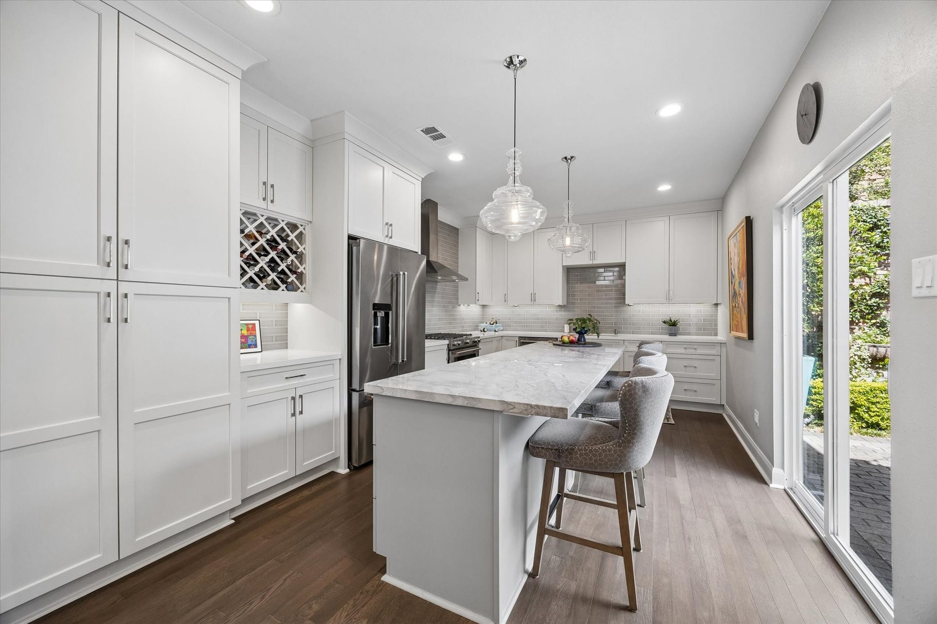 KITCHEN: Beautifully redesigned kitchen showcases custom cabinetry, marble countertops, stainless steel appliances including gas range and a spacious island with seating.