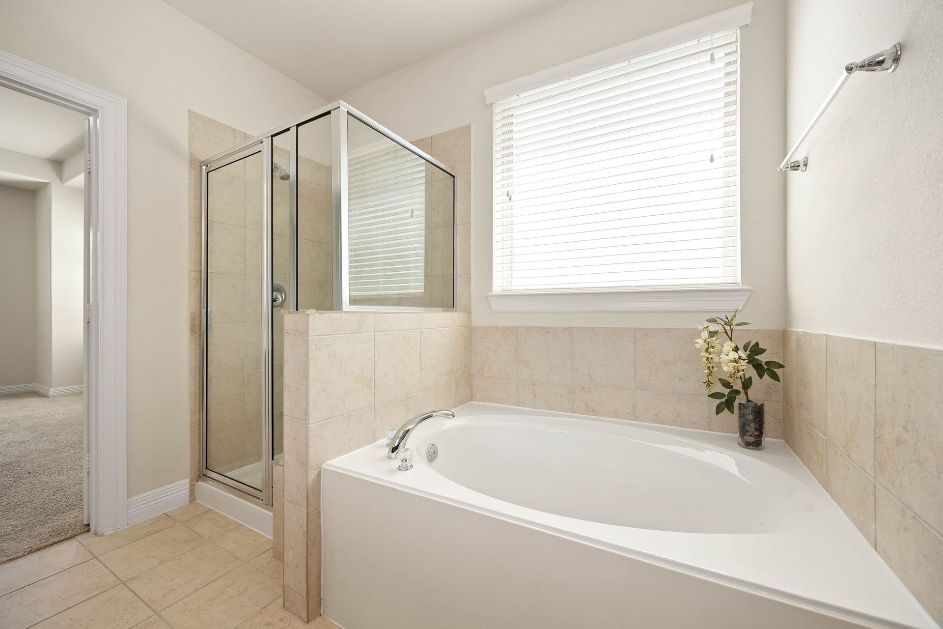 26306 Sunny Springs Lane, Cypress, TX 77433 Relaxing soaking tub and separate glass-enclosed shower complete this primary bathroom with a large window providing great natural light.