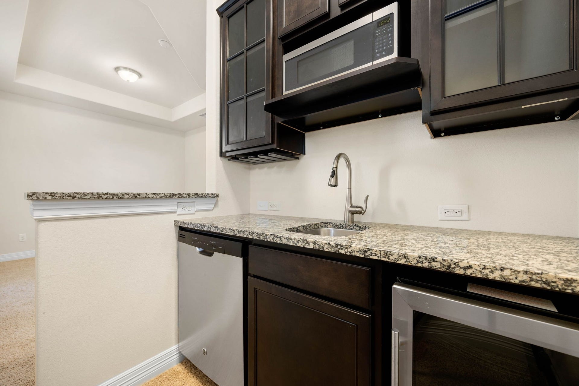 26306 Sunny Springs Lane, Cypress, TX 77433 The private living space in this second floor primary suite also features a convenient kitchenette with granite countertops, sink, cabinets, dishwasher, and wine fridge!