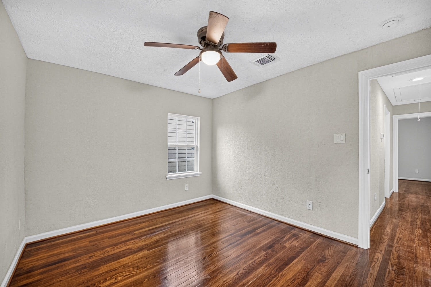 Bedroom 3 
with ceiling fan and refinished original wood flooring.