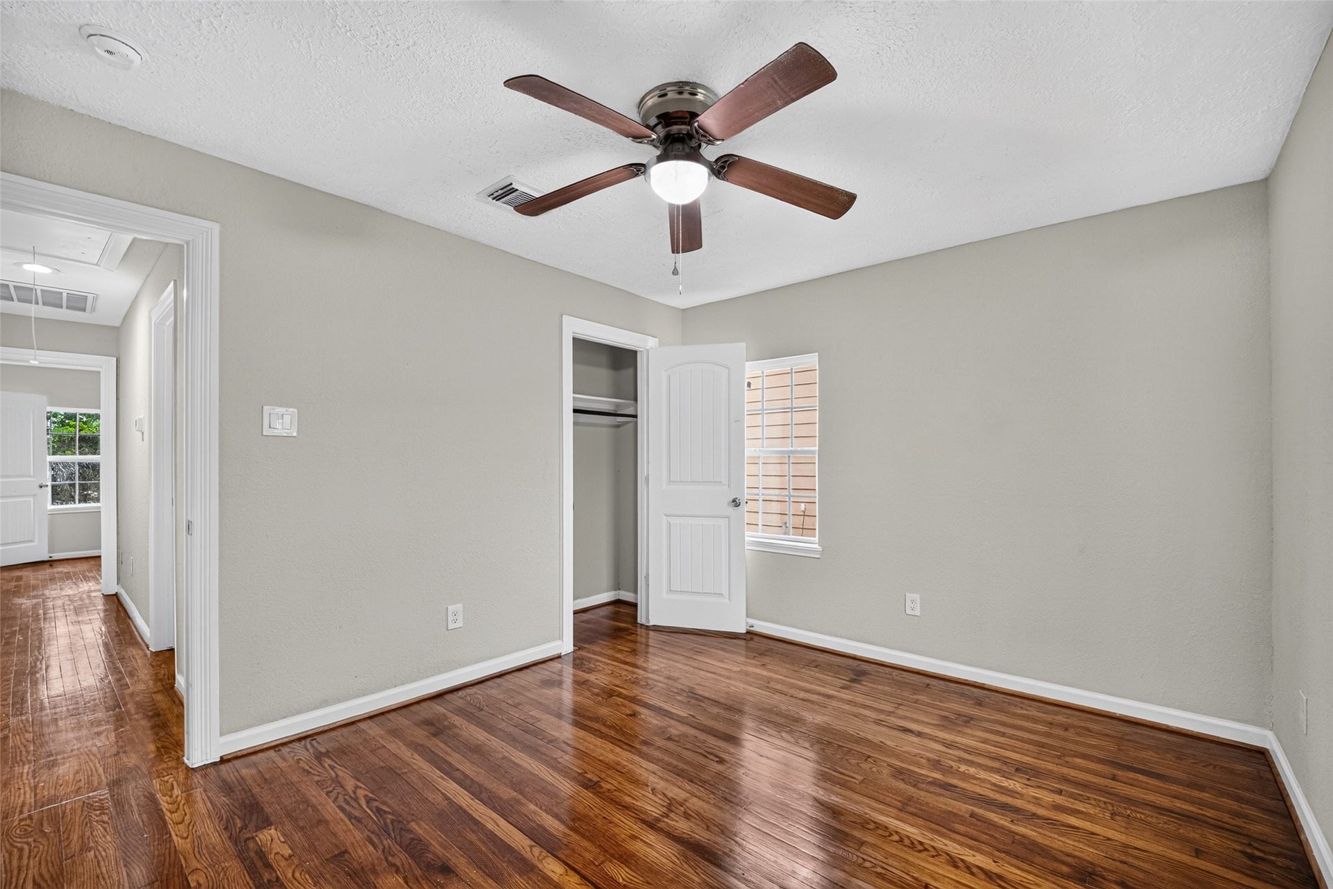 Bedroom 1 
with ceiling fan and refinished original wood flooring.