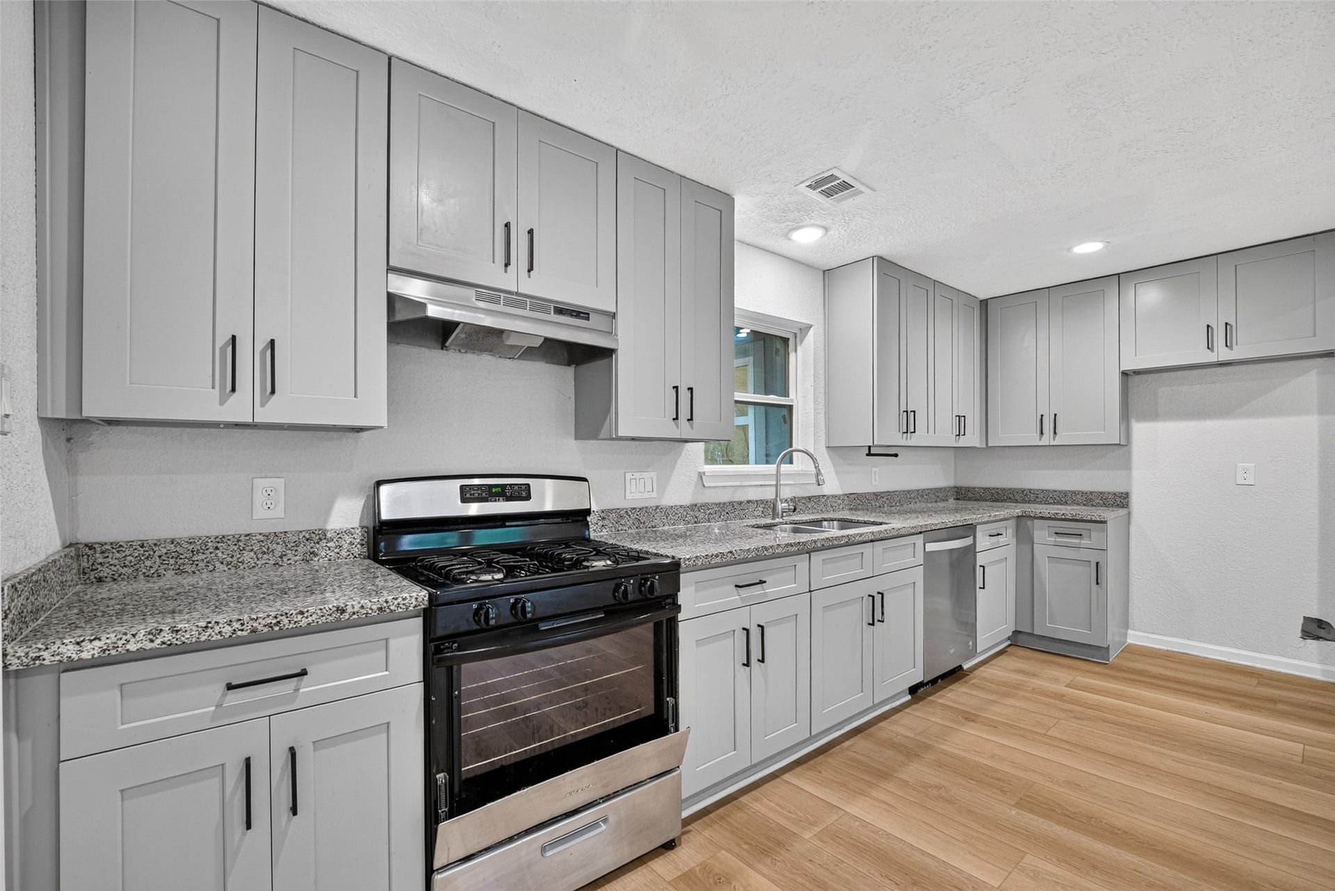 Stainless and black range and dishwasher enhance the decor.