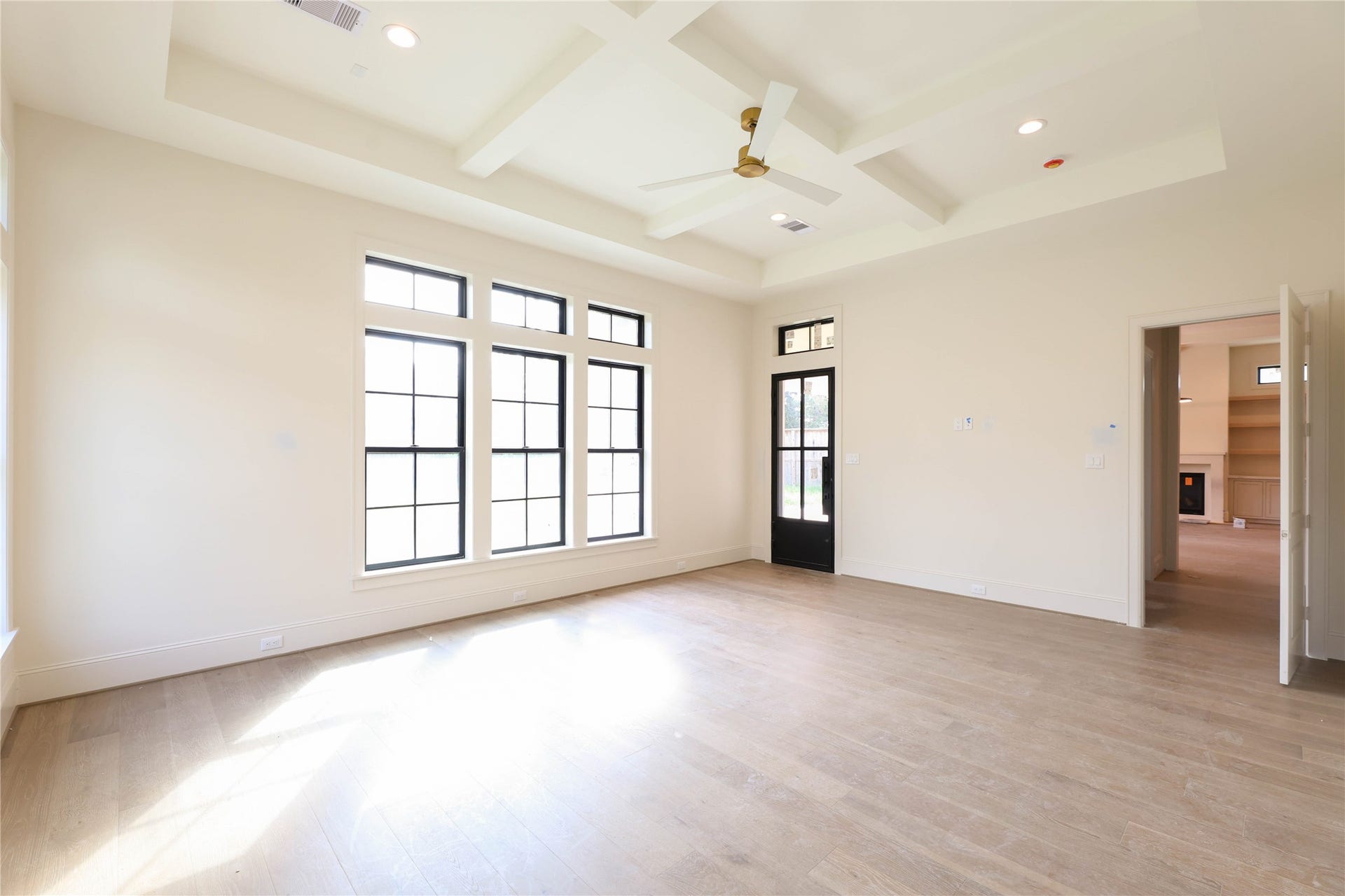 752 W 43rd Street, Houston, TX 77018 Primary Bedroom features engineered wood floors, coffered ceilings, Andersen windows, Metal frame door leading to the back patio & a masterful Primary Bathroom with over-sized shower, soak tub, 2 vanities & massive walk-in closet.