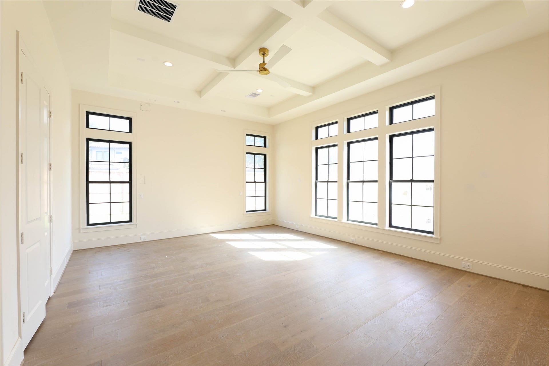 752 W 43rd Street, Houston, TX 77018 Primary Bedroom features engineered wood floors, coffered ceilings, Andersen windows, Metal frame door leading to the back patio & a masterful Primary Bathroom with over-sized shower, soak tub, 2 vanities & massive walk-in closet.